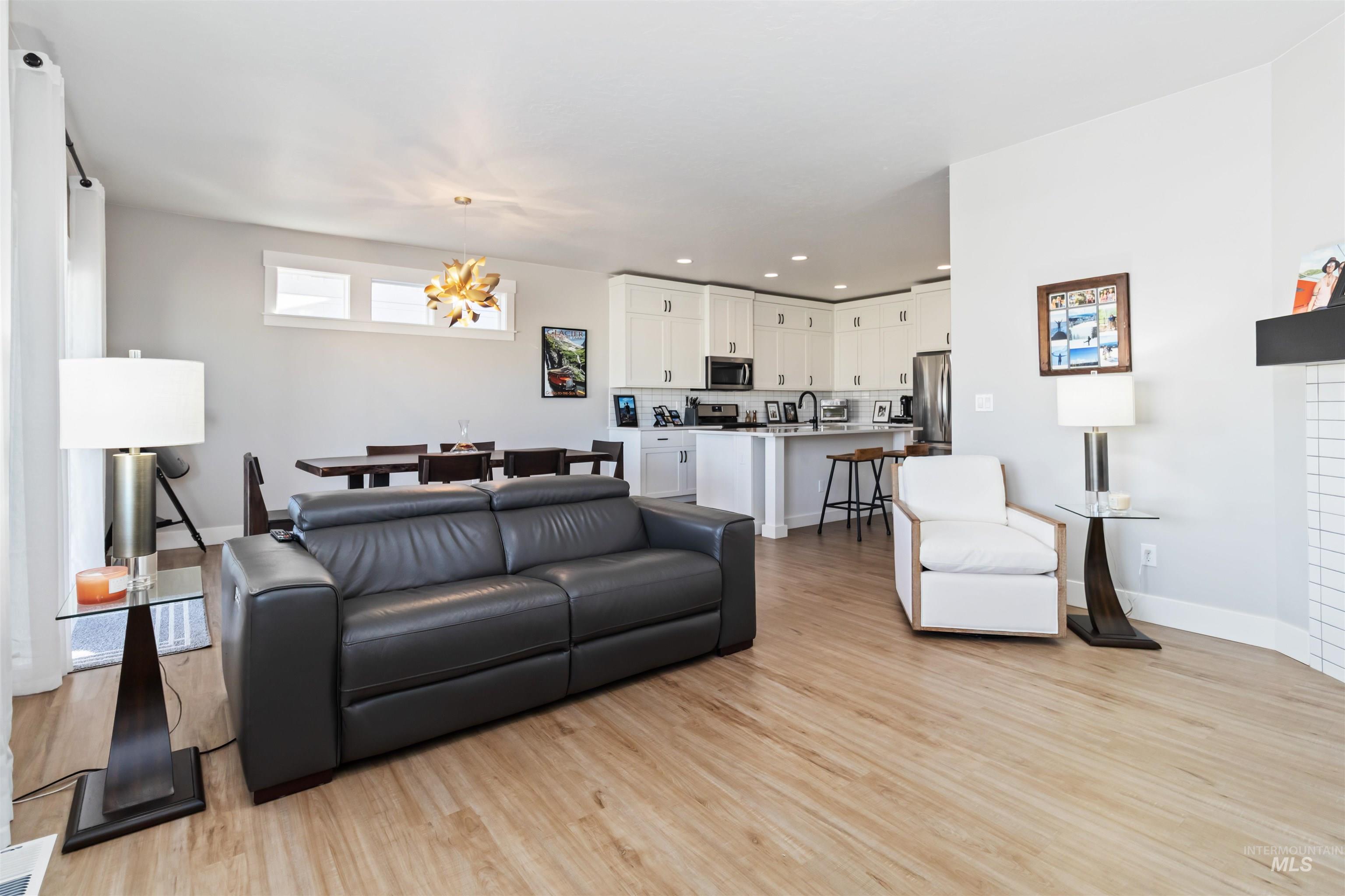 Living area featuring light wood finished floors, recessed lighting, and a chandelier