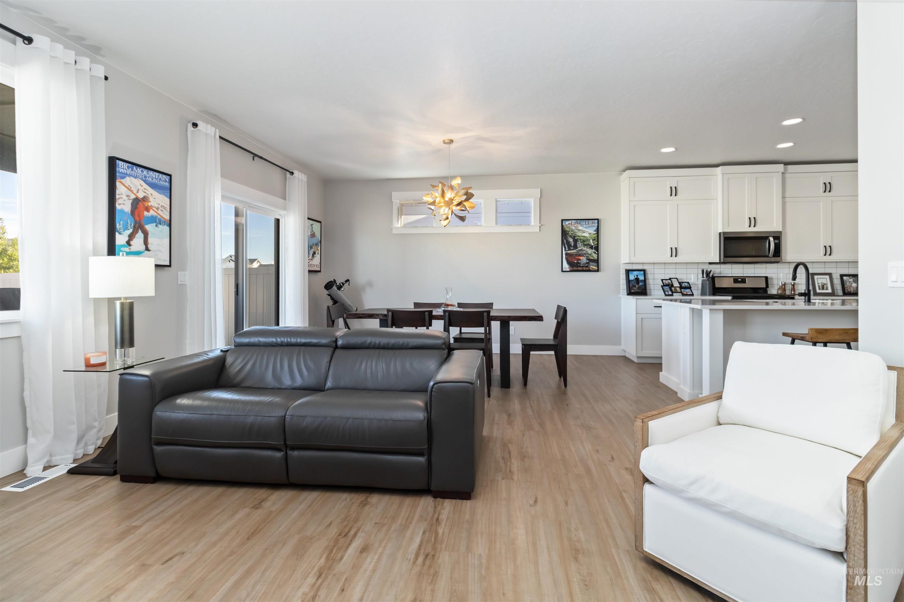 Living area featuring a chandelier, light wood-style floors, and recessed lighting