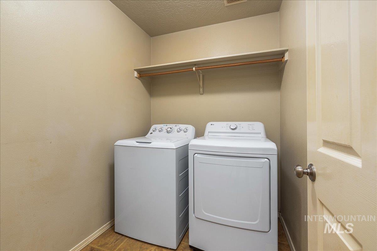 Laundry room featuring a textured ceiling and washer and dryer