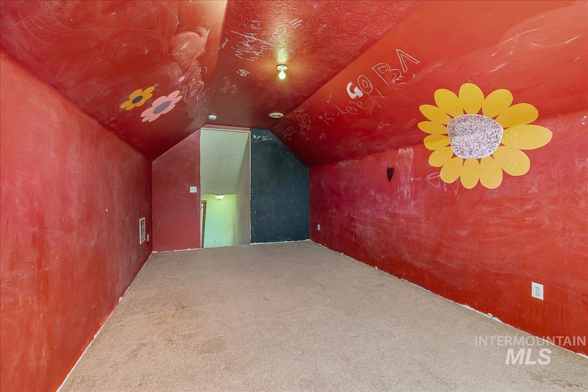 Additional living space with lofted ceiling and carpet