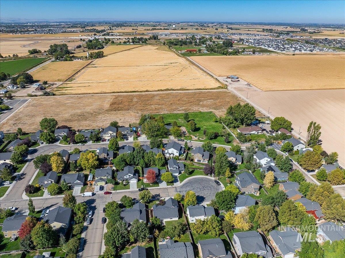 Aerial view of property and surrounding area featuring nearby suburban area