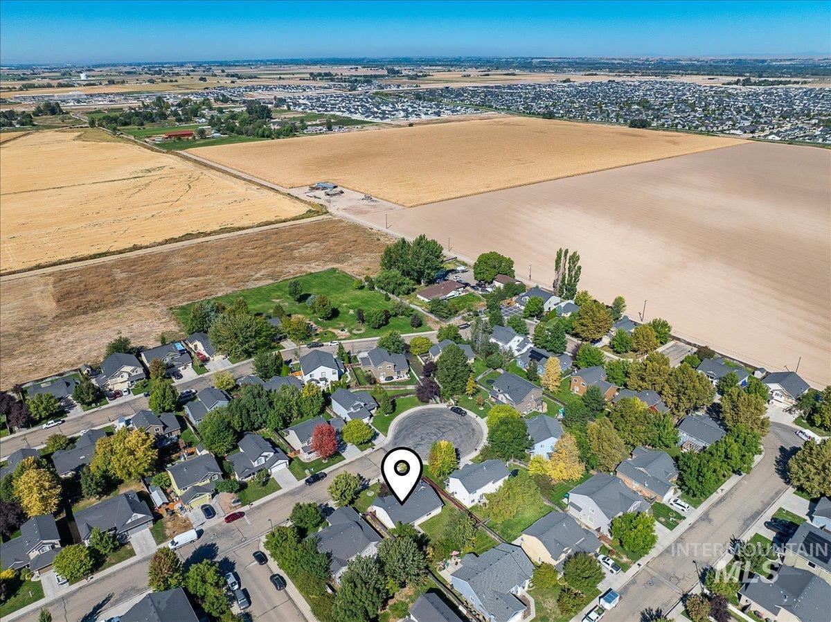 Aerial view of property and surrounding area with nearby suburban area