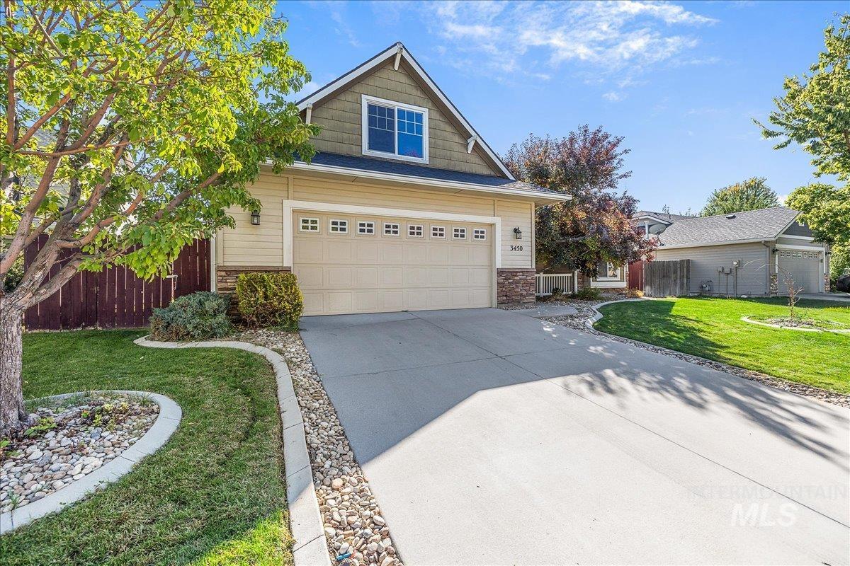 View of front of home with concrete driveway and stone siding