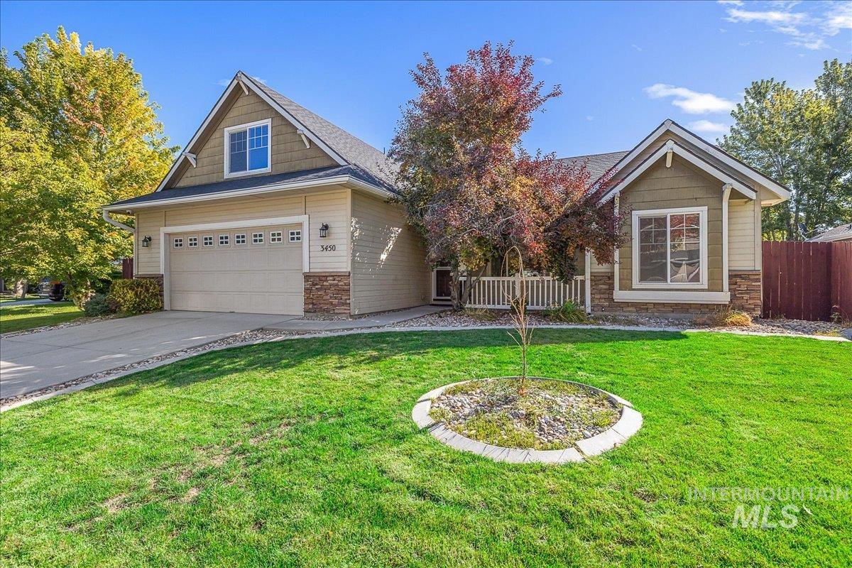 Craftsman inspired home with driveway, stone siding, and roof with shingles