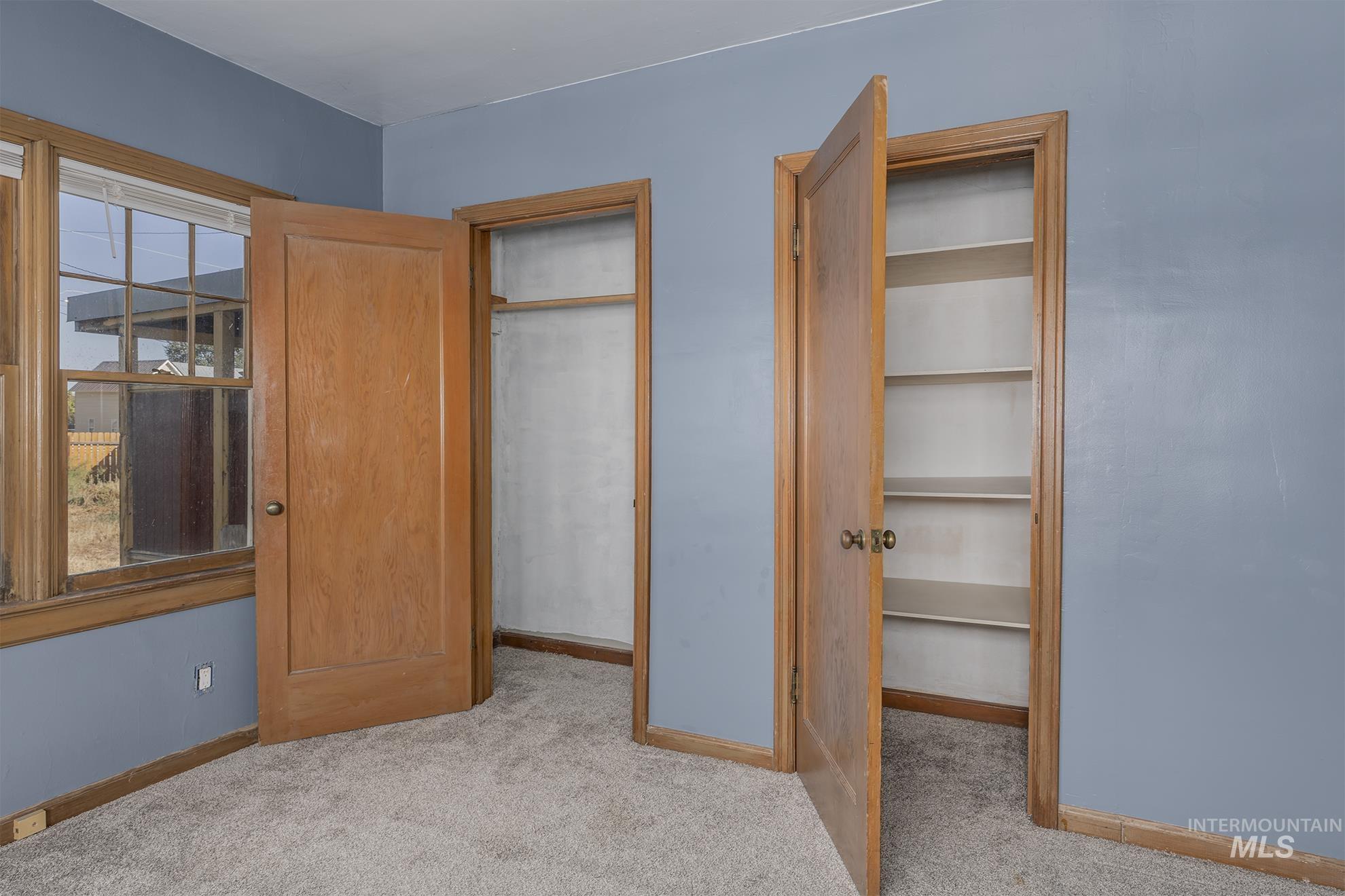 Unfurnished bedroom with light carpet and a closet