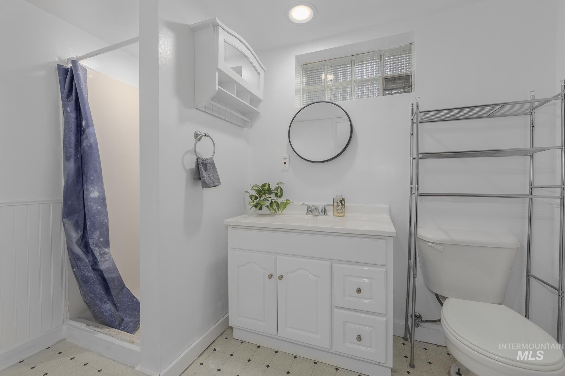 Full bathroom with vanity, a shower stall, light floors, and recessed lighting