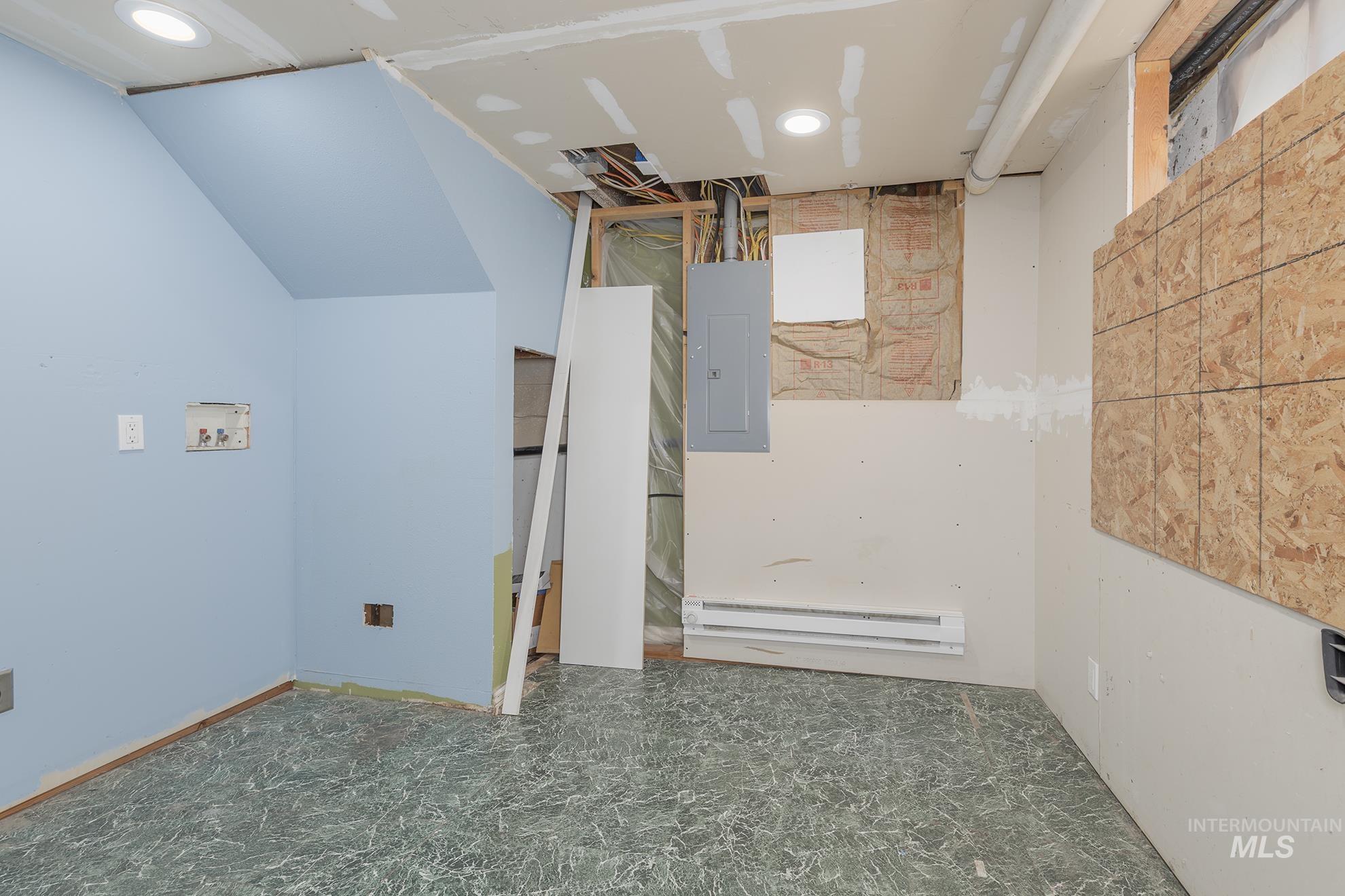 Unfurnished room featuring electric panel, baseboard heating, and recessed lighting