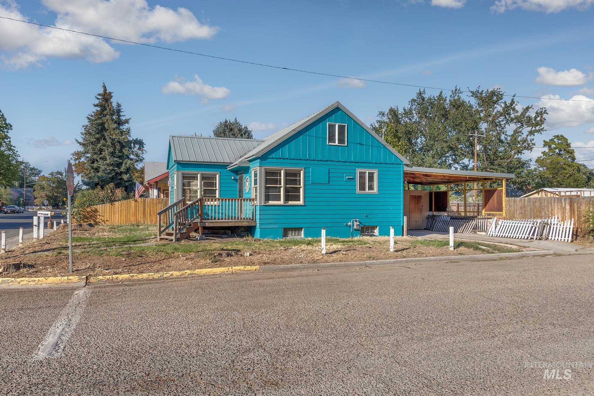 View of front of home with an attached carport, a patio area, and a metal roof