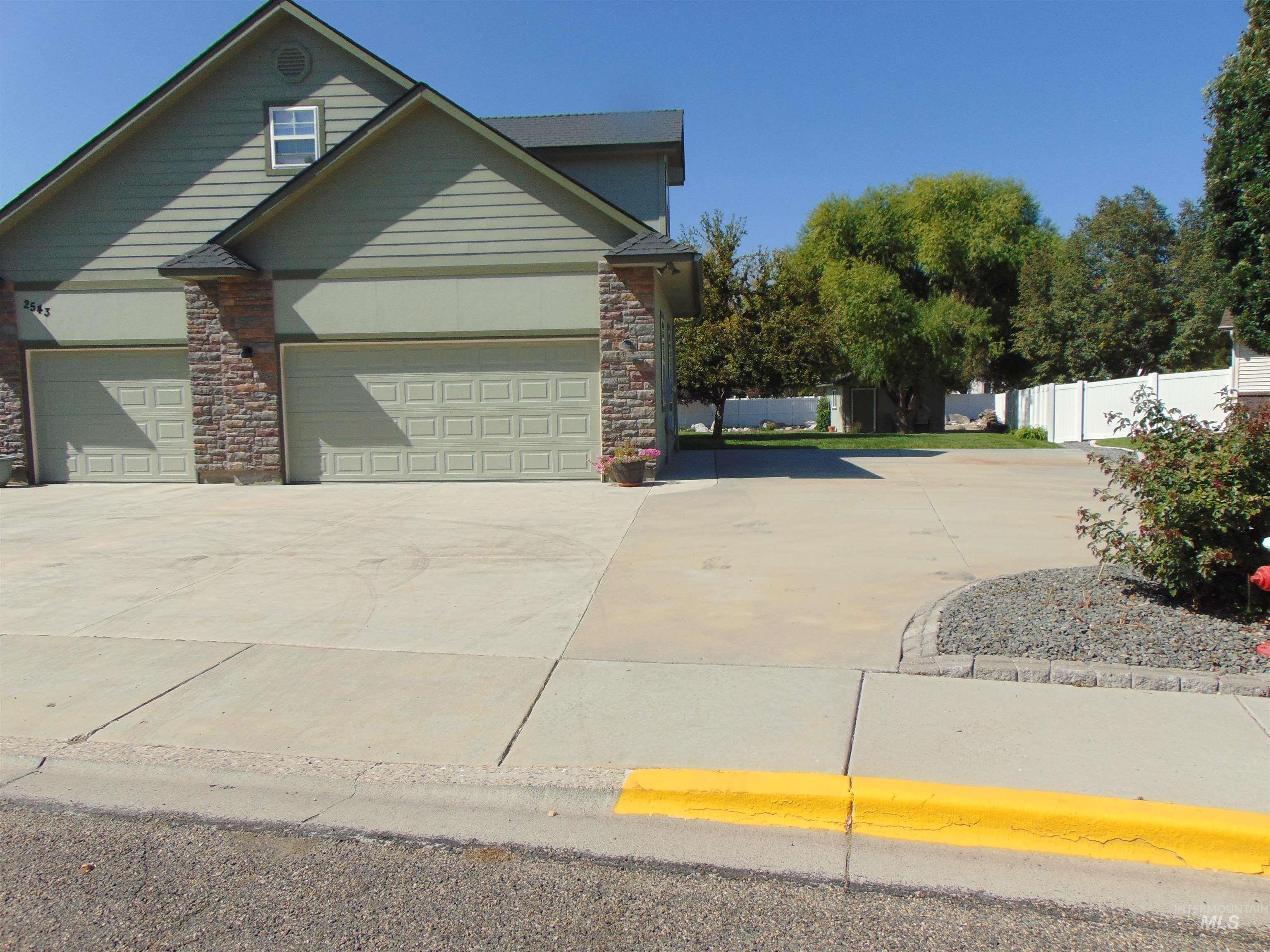View of front of house featuring driveway and stone siding