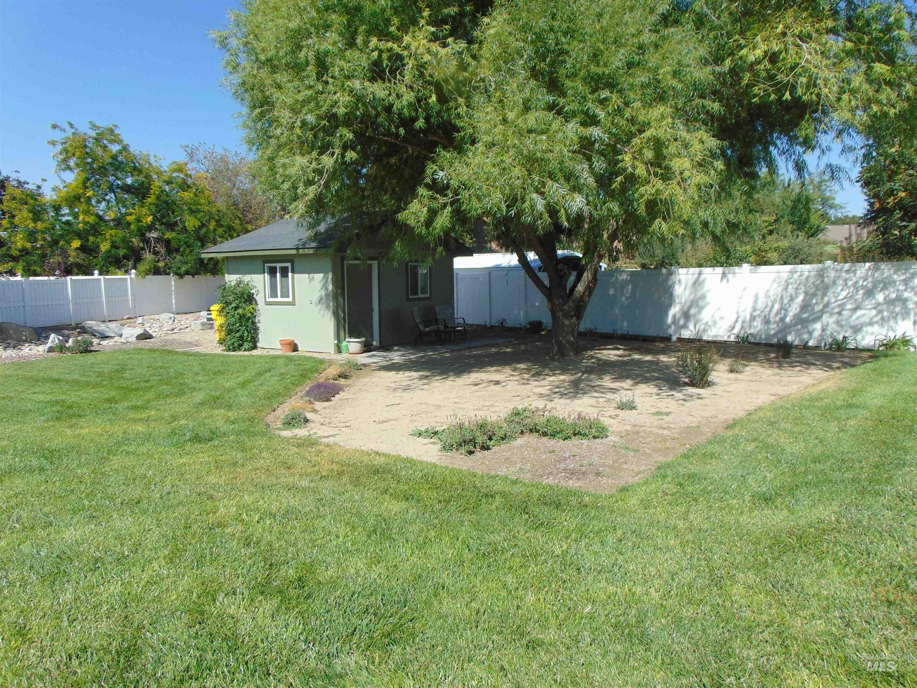 Fenced backyard with an outbuilding