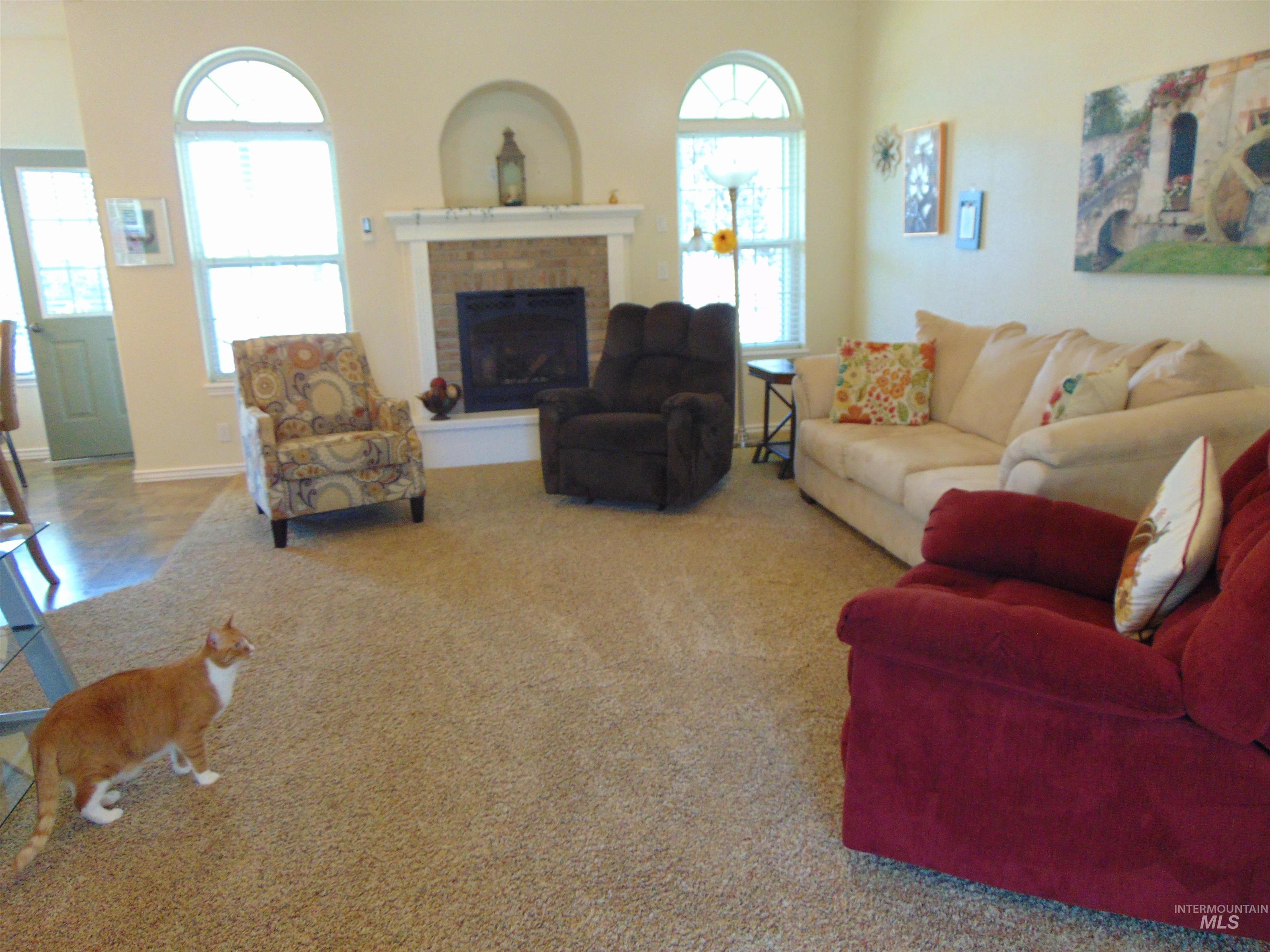 Living room featuring carpet flooring and a brick fireplace