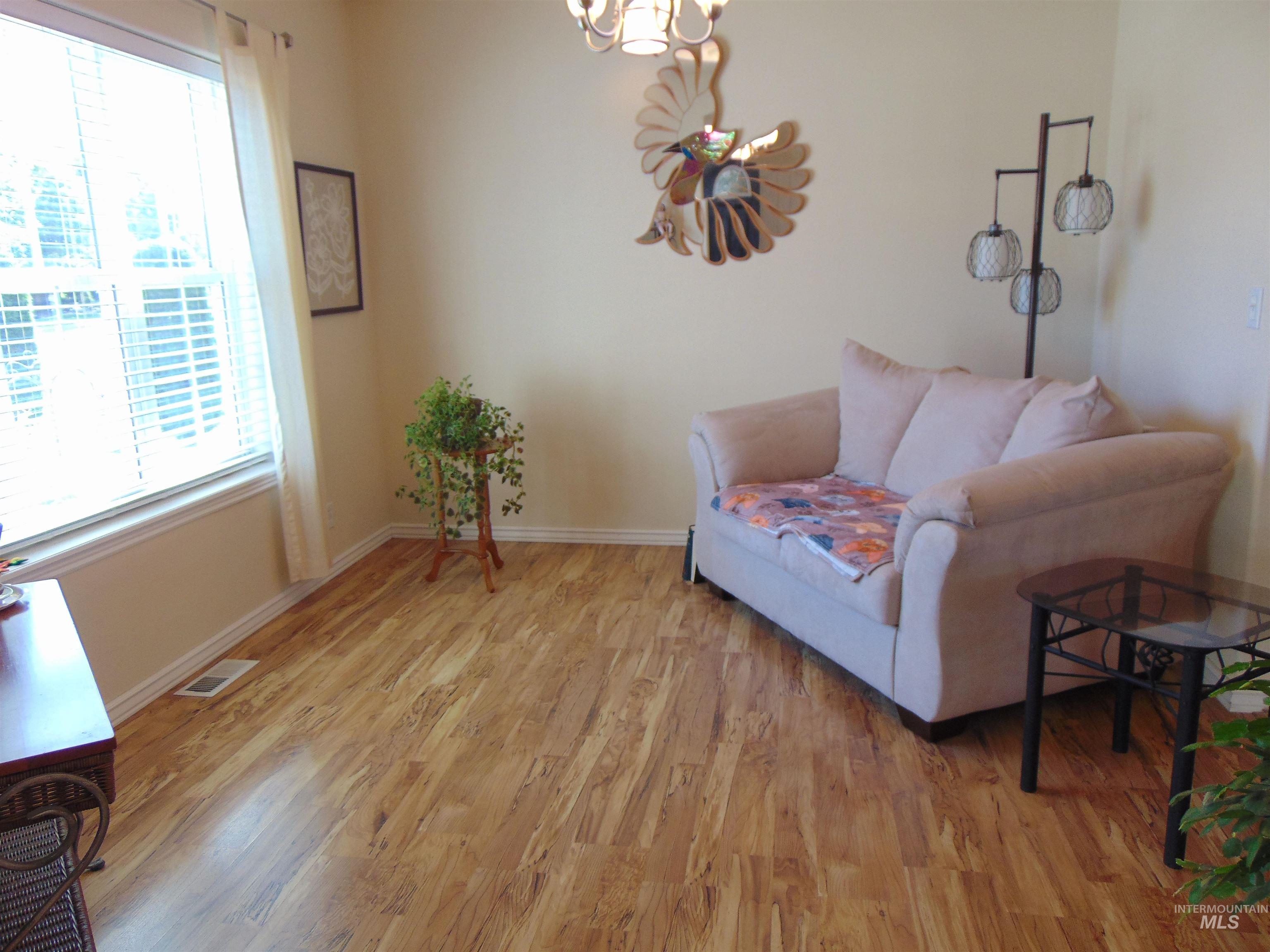 Sitting room with light wood-style flooring and a chandelier