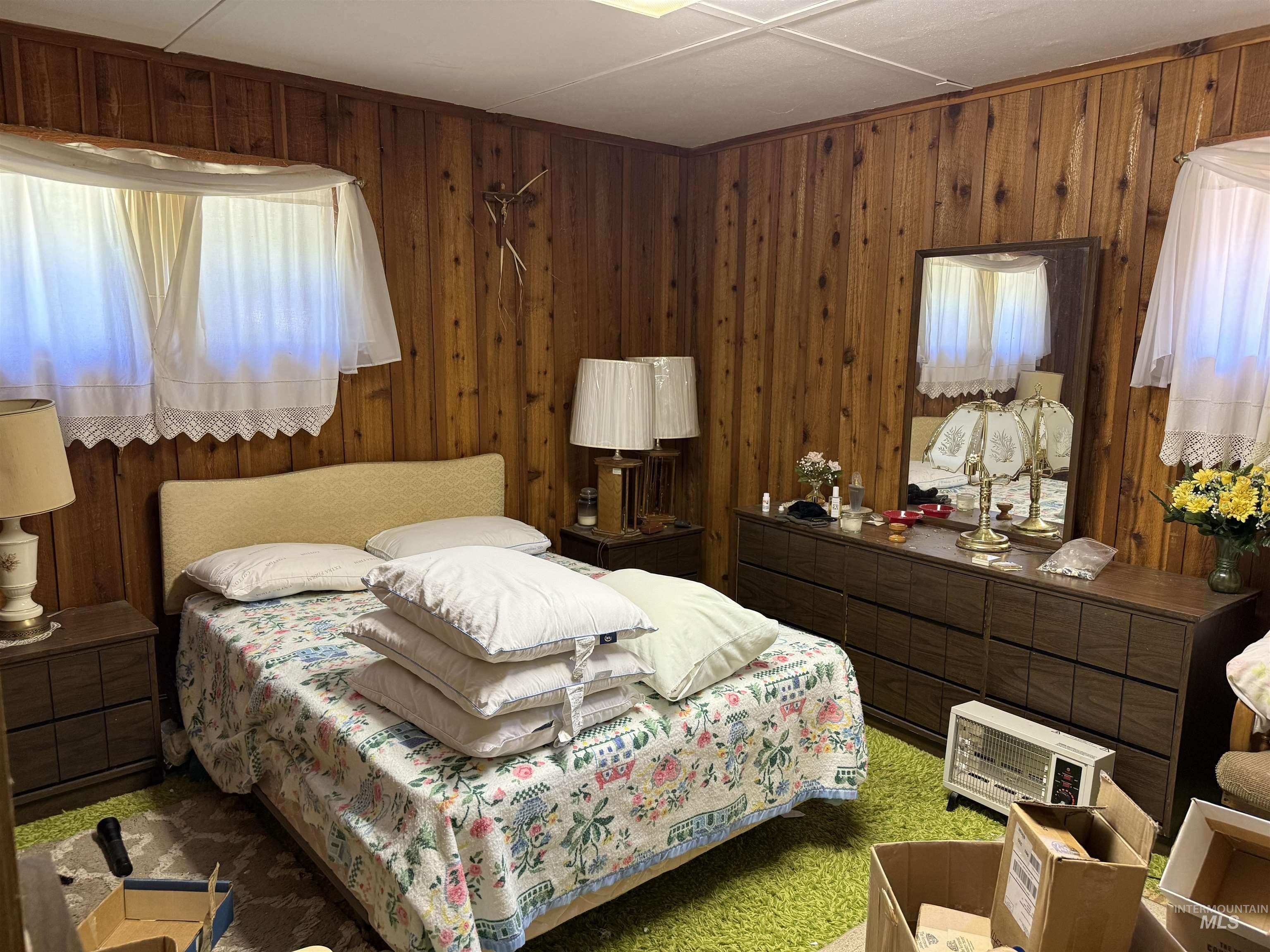 Bedroom with carpet floors and wood walls