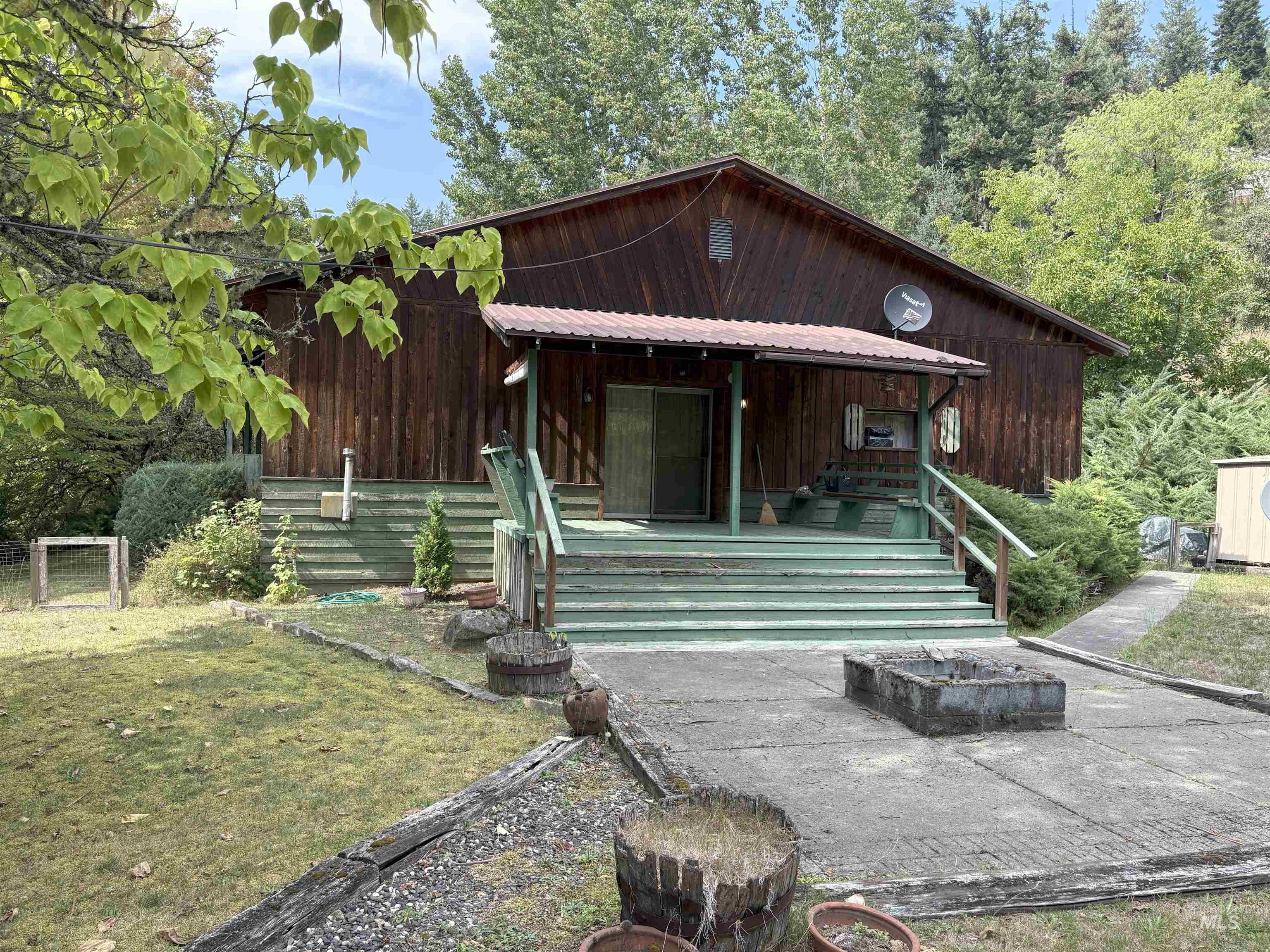 Rear view of property with a porch, a metal roof, and a yard