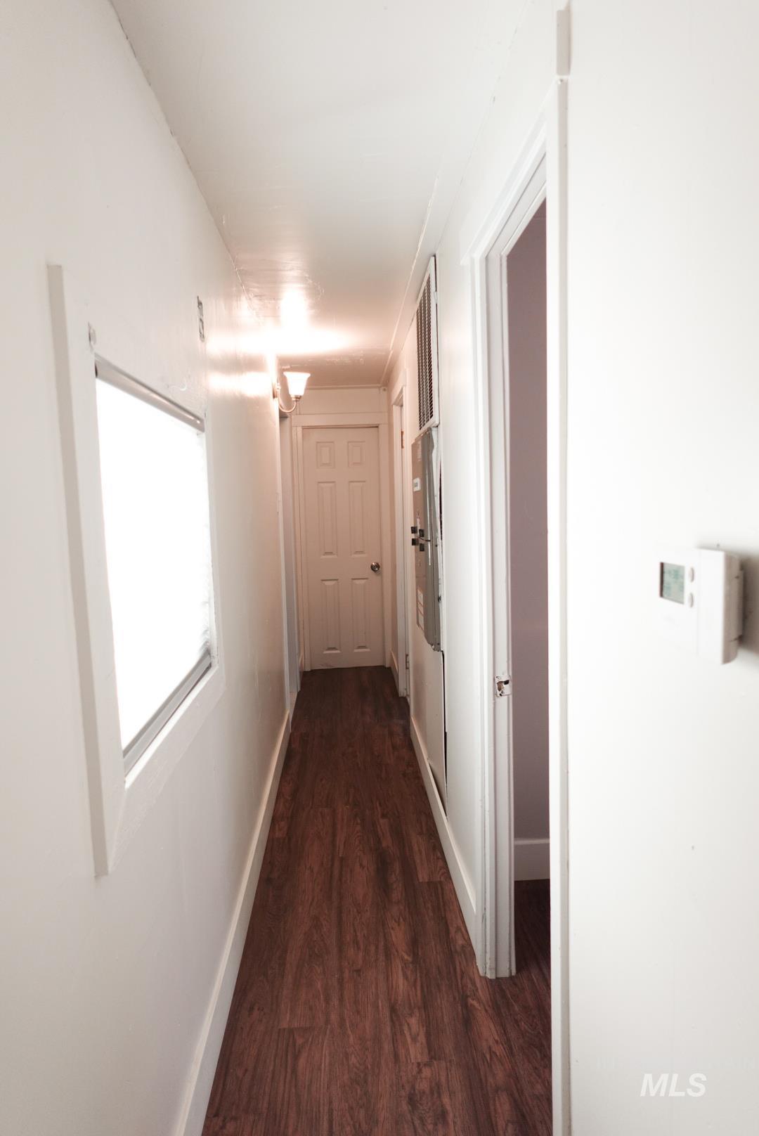 Hall featuring dark wood finished floors and baseboards