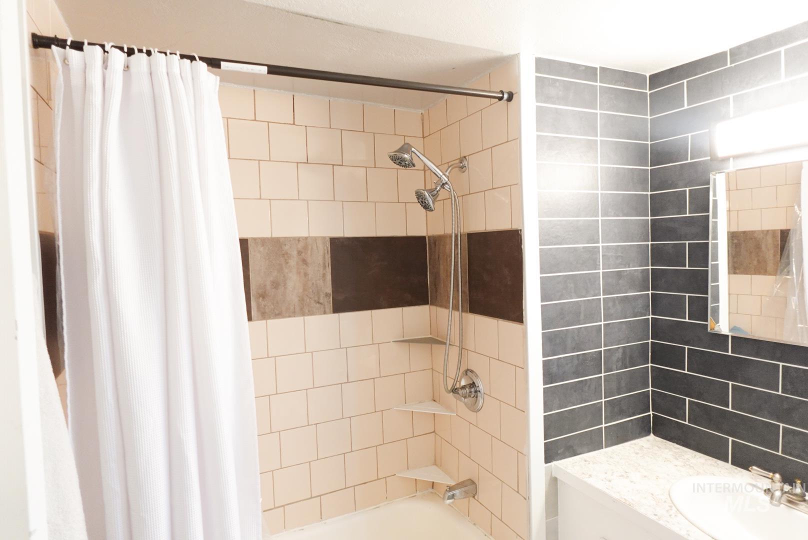 Full bath featuring shower / tub combo and vanity