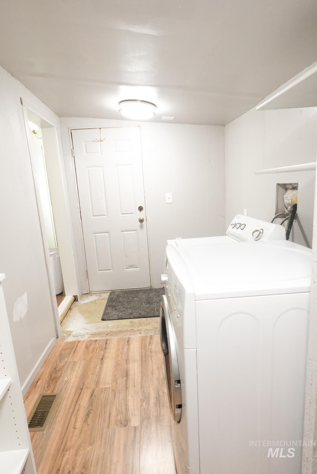Washroom with washer / dryer and light wood finished floors