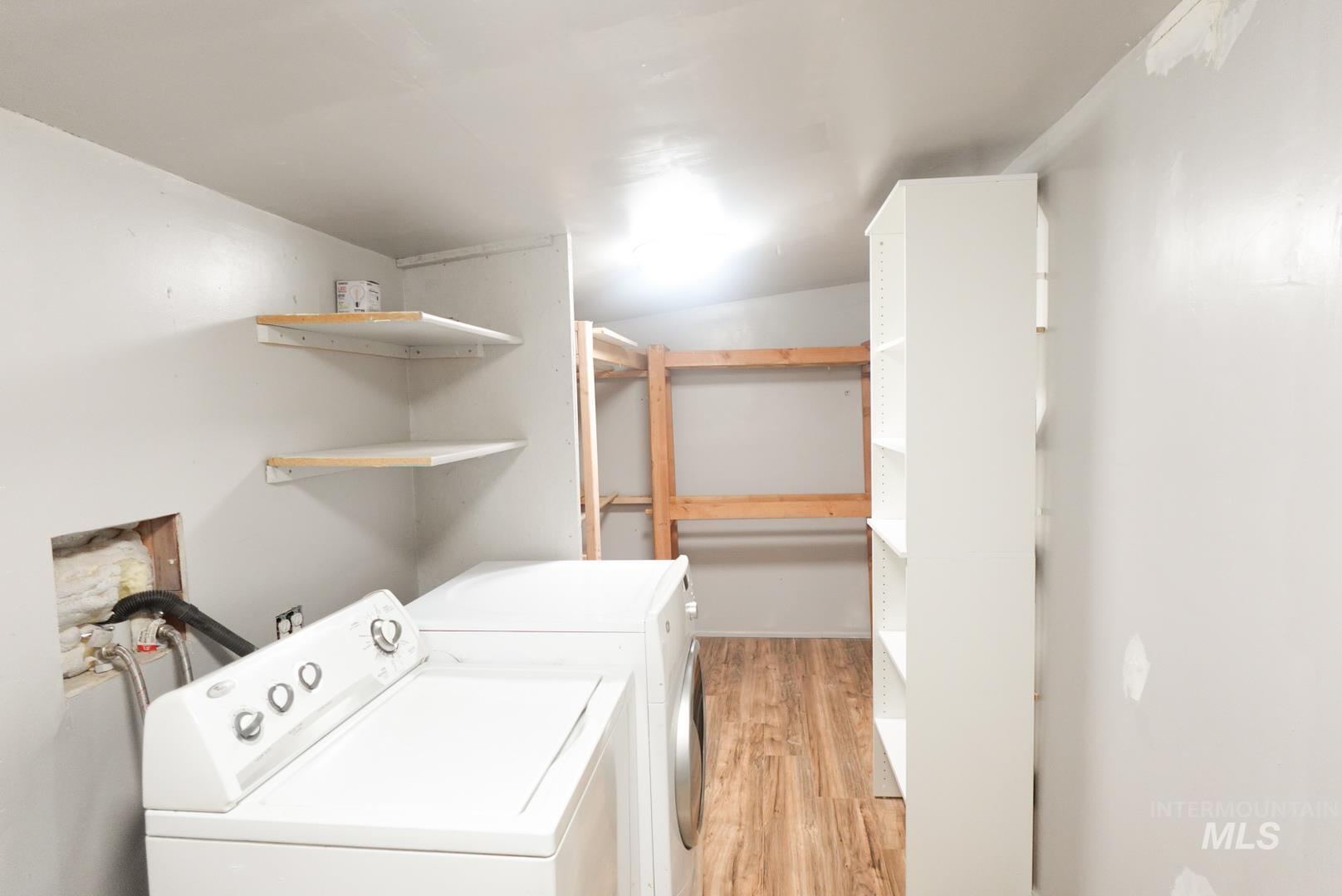 Washroom featuring light wood-style floors and separate washer and dryer