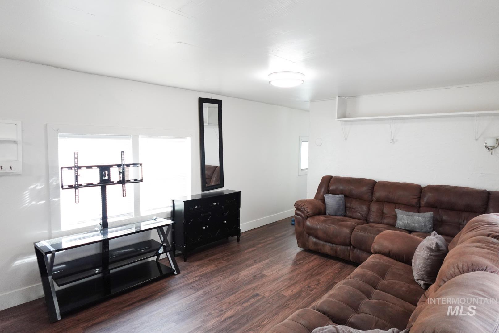 Living area featuring dark wood finished floors and baseboards