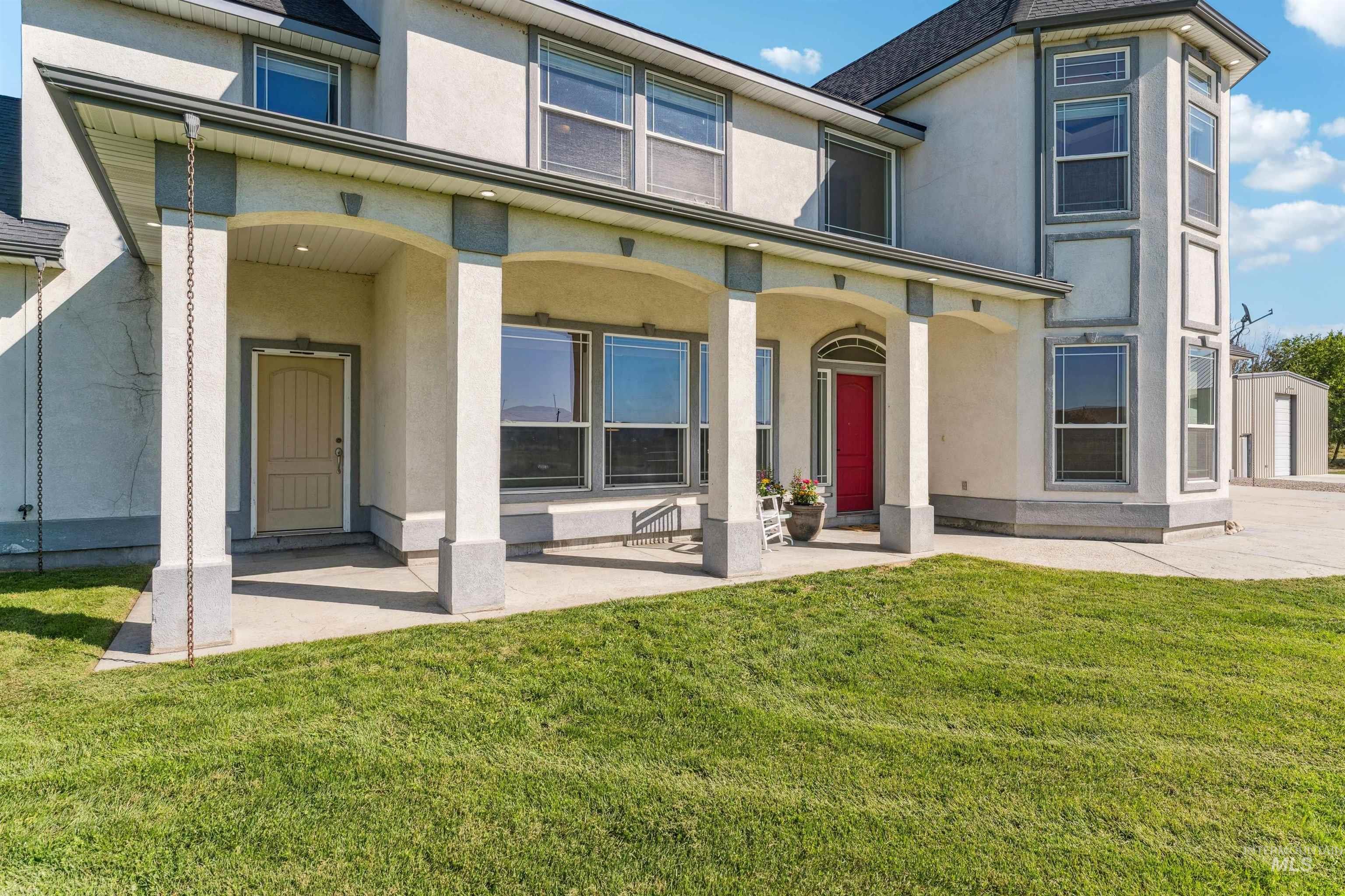 Back of property featuring stucco siding, a porch, and a yard