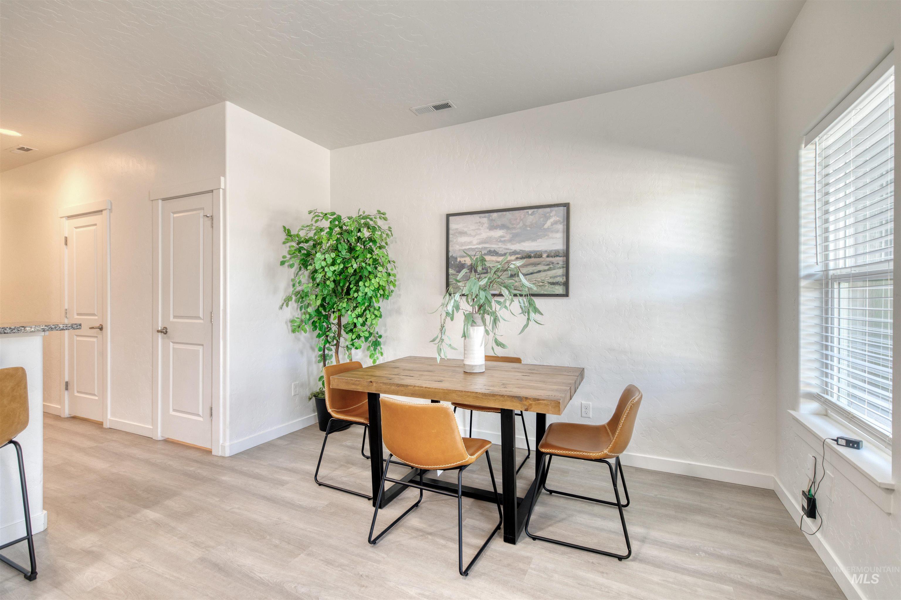 Dining room featuring light wood-style floors and healthy amount of natural light