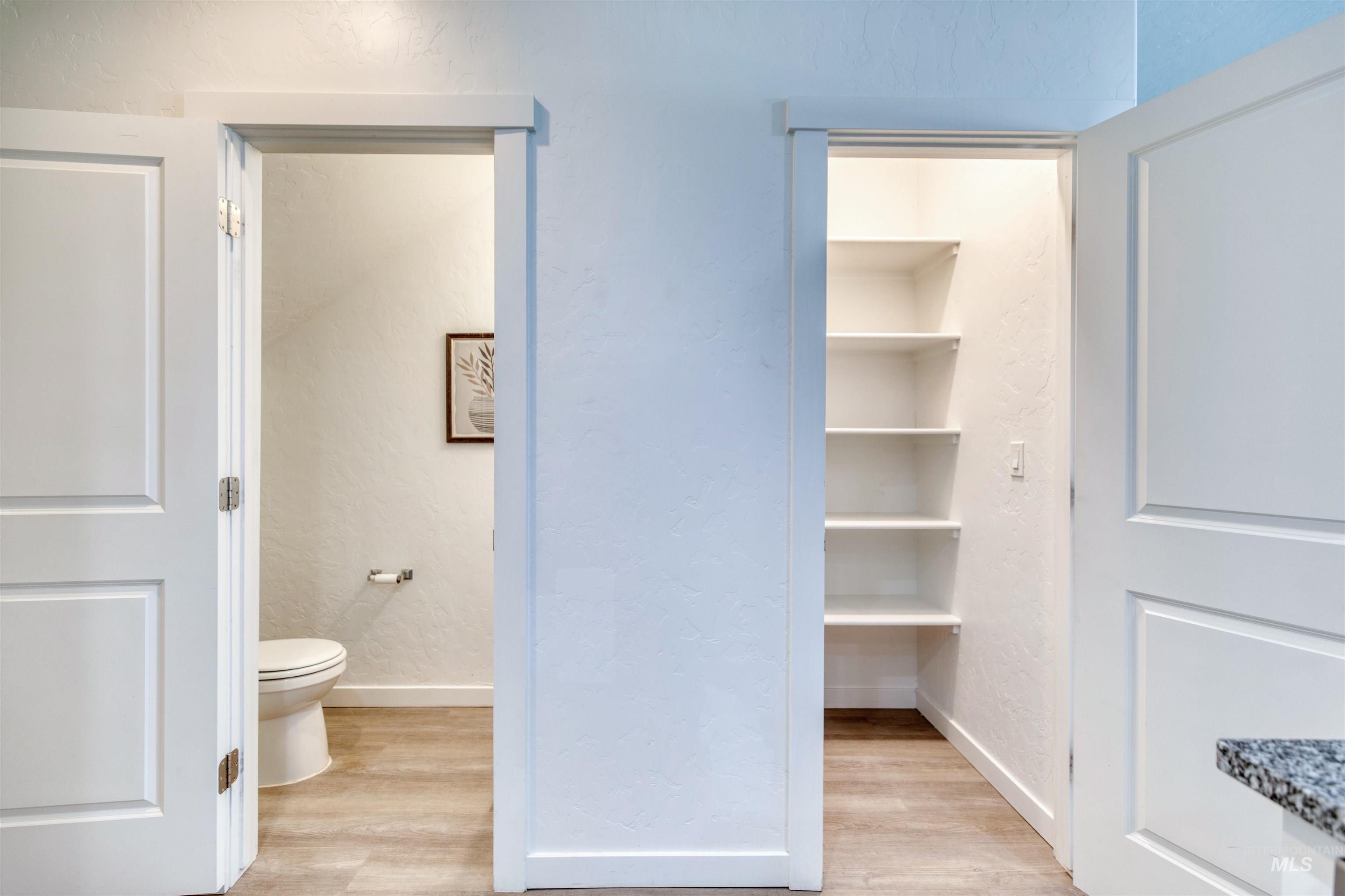 Bathroom with light wood-style floors and a textured wall