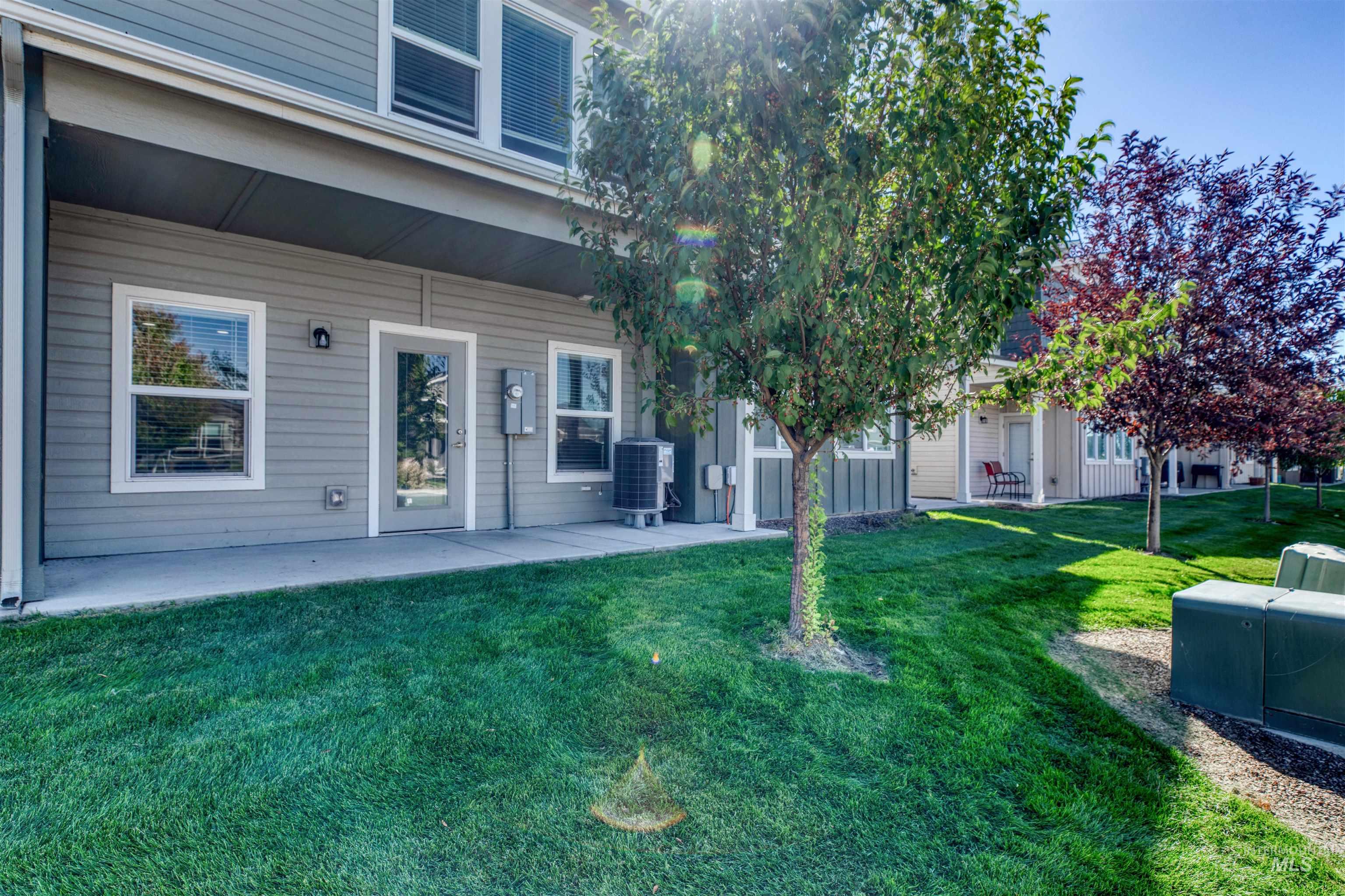 Entrance to property featuring a lawn and a patio
