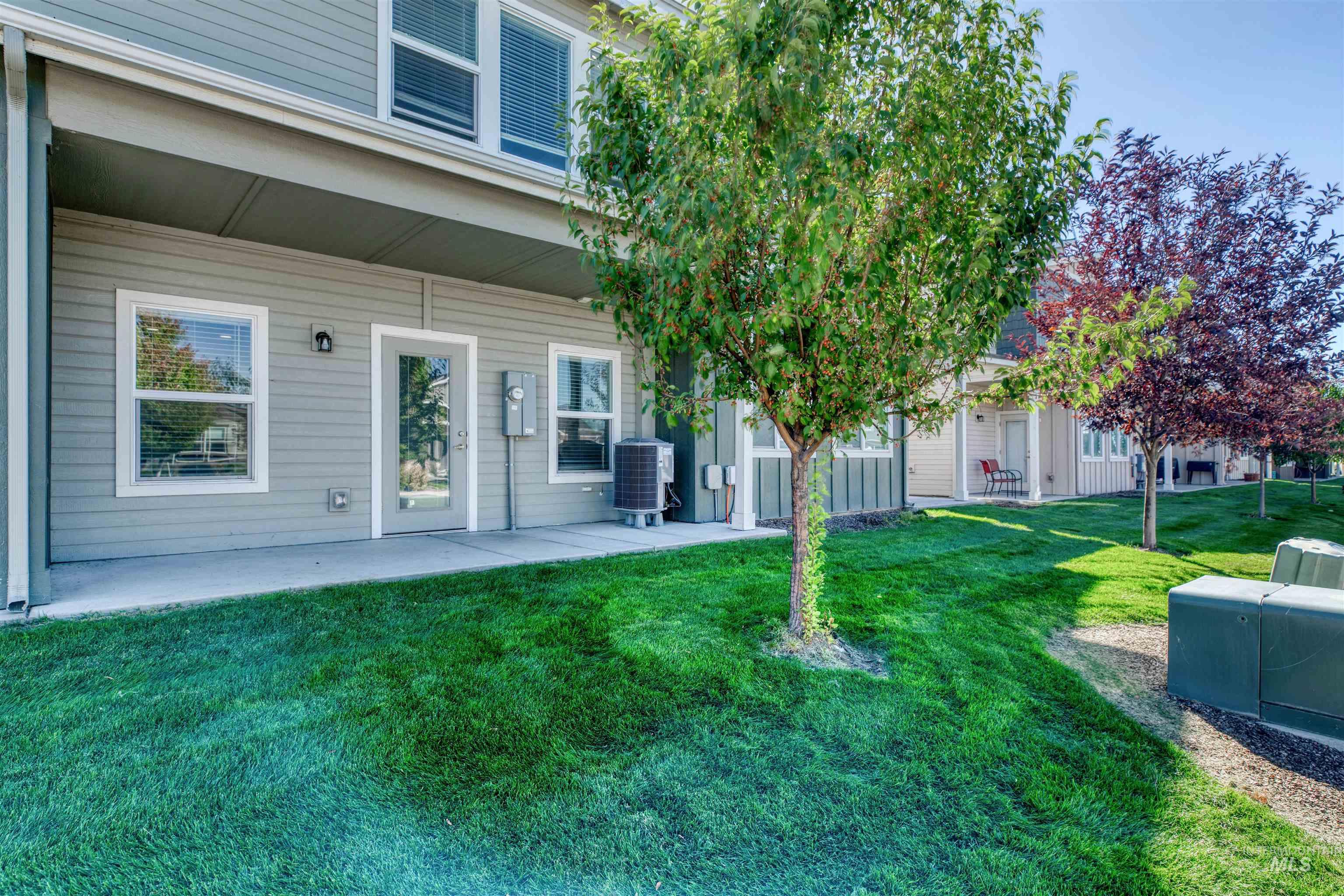 Property entrance with a yard and a patio