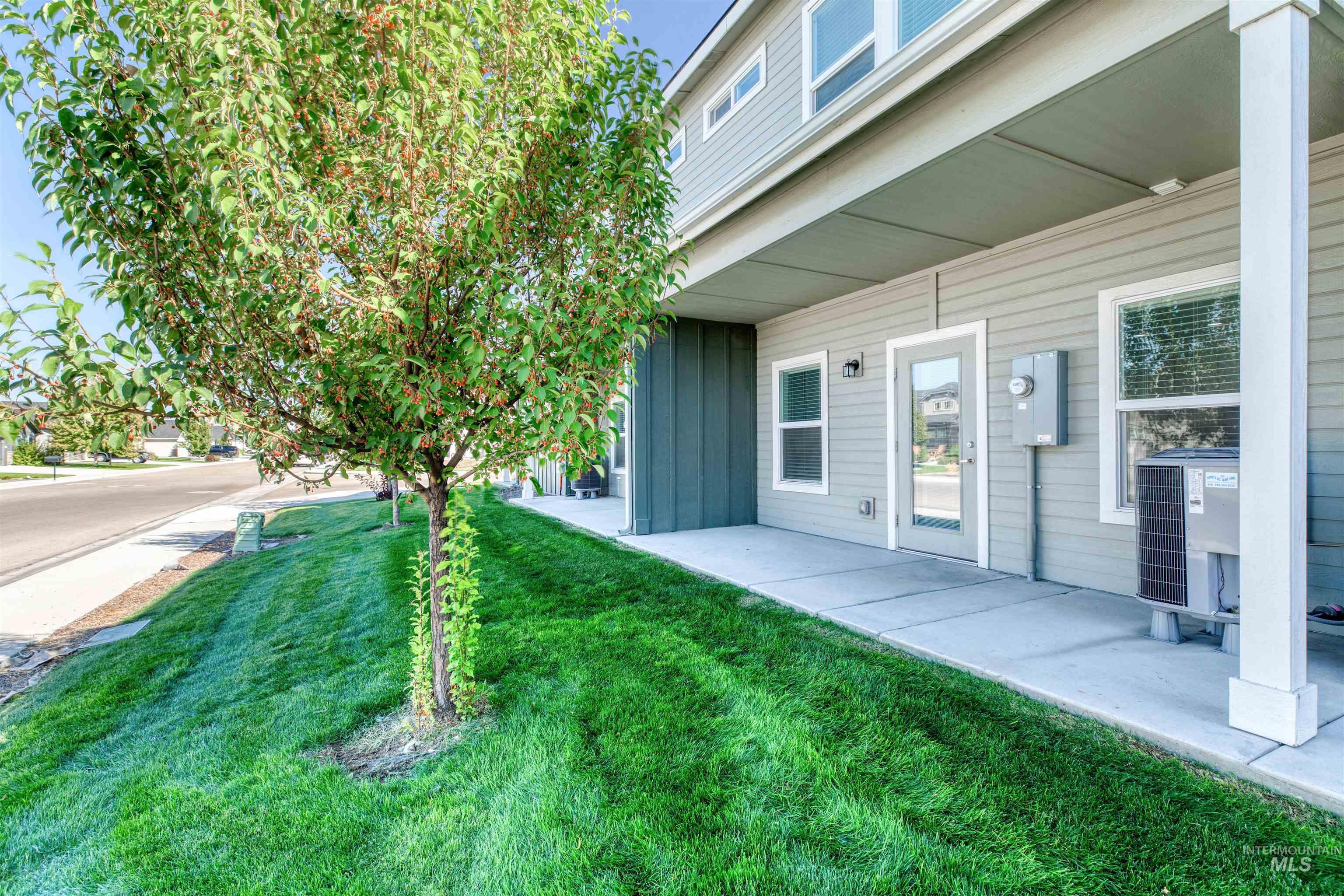 View of green lawn with a patio area