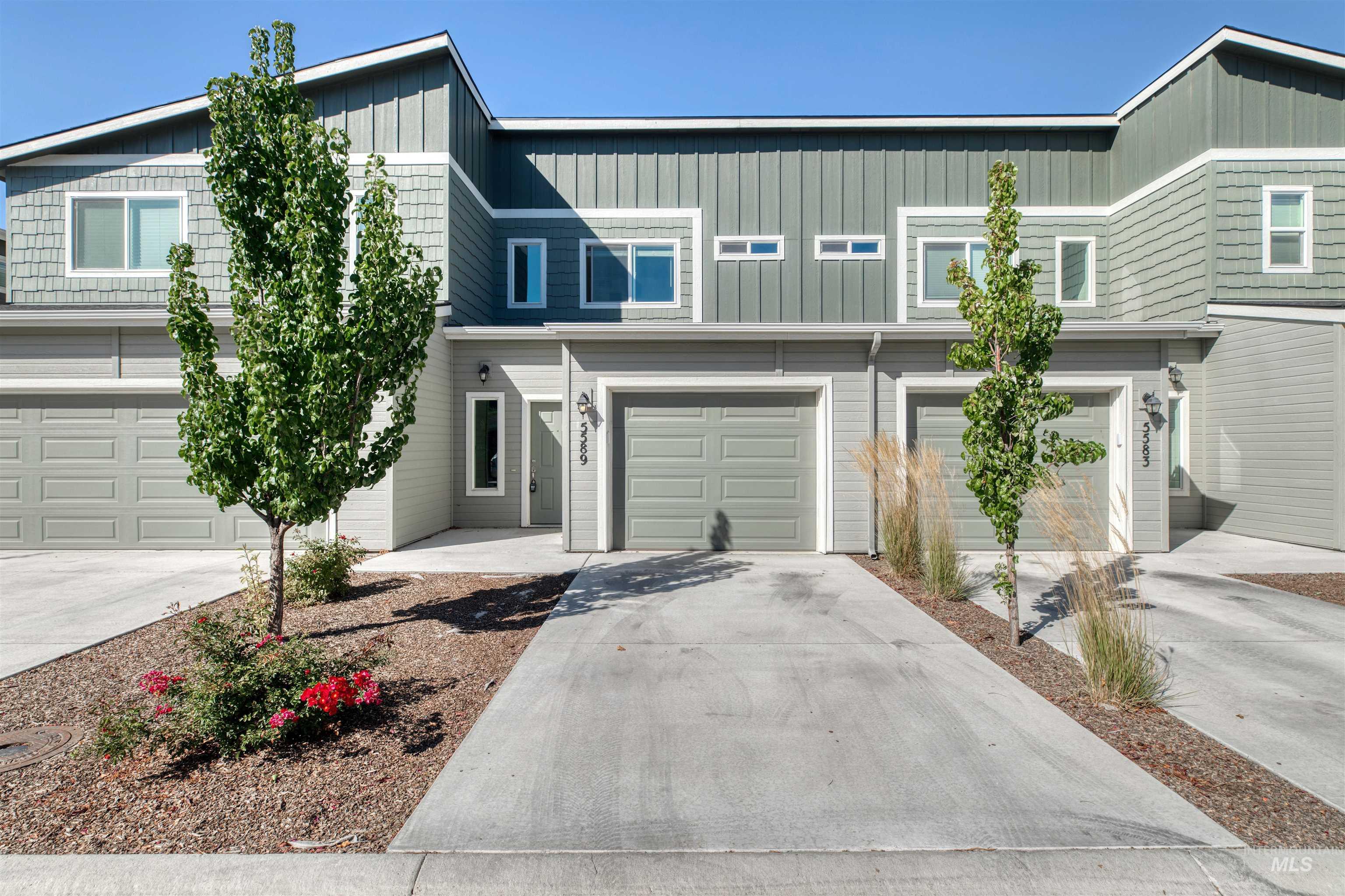 View of front of property featuring driveway, a garage, and board and batten siding