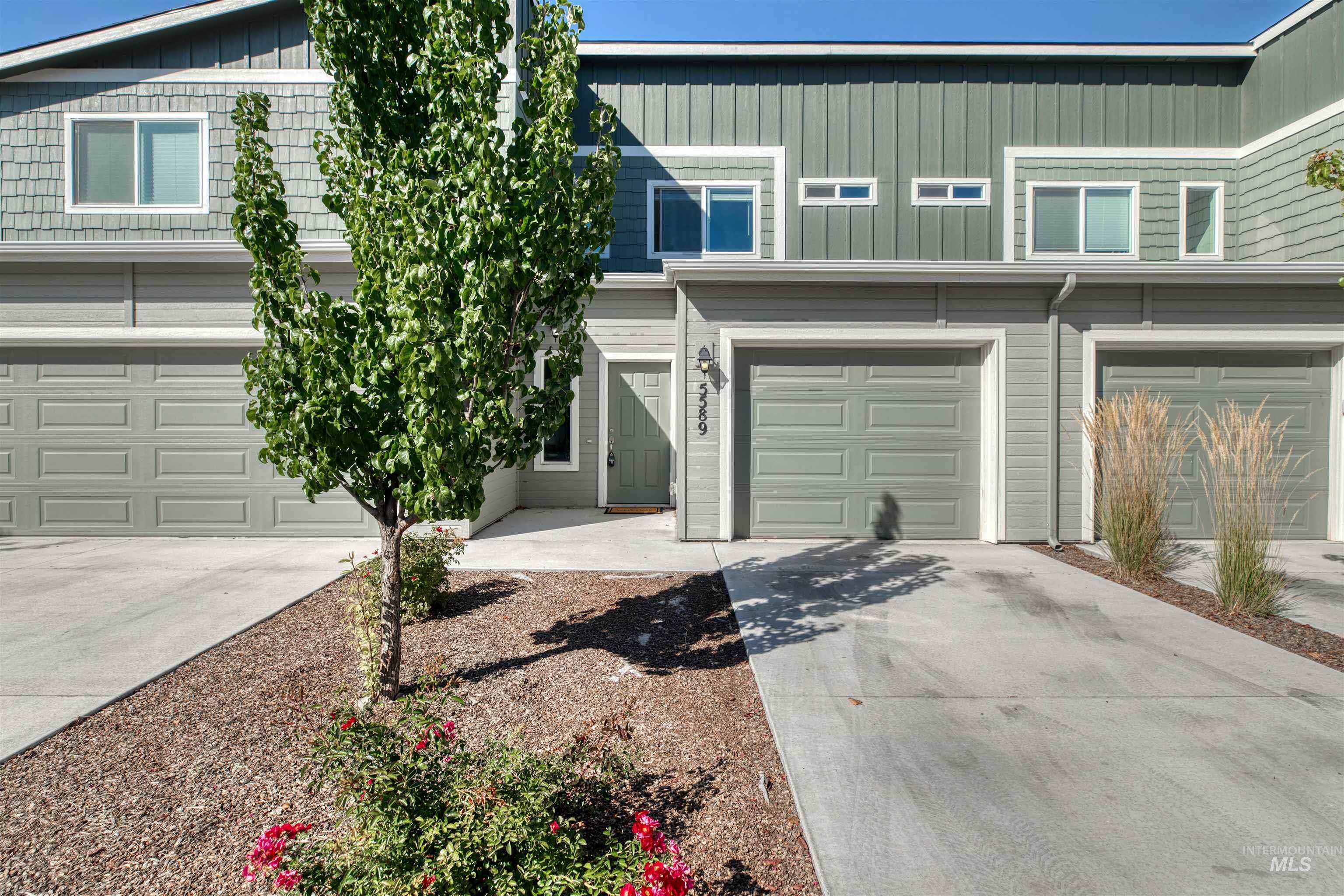 Traditional-style house featuring concrete driveway, board and batten siding, and an attached garage