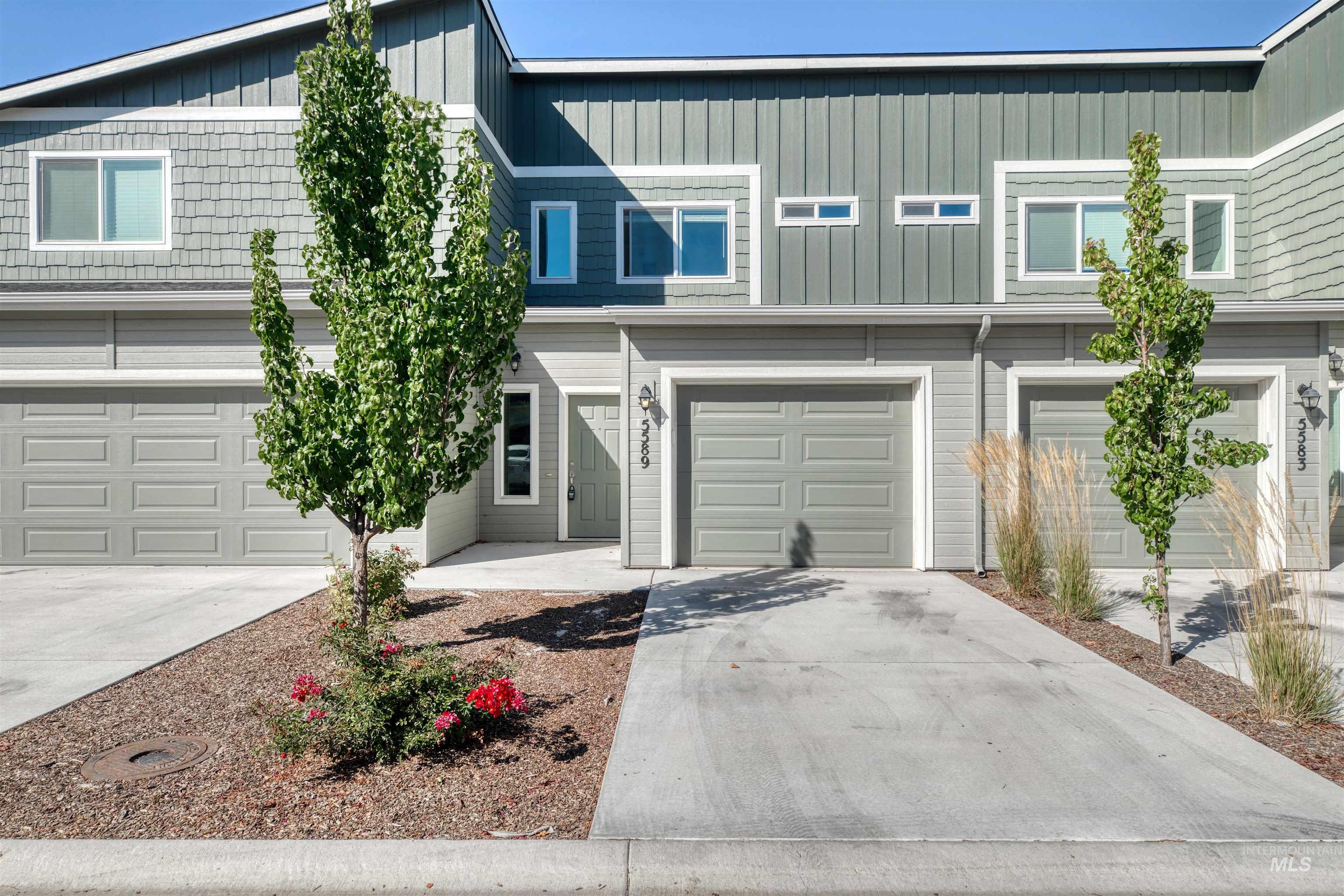 View of front facade with driveway, a garage, and board and batten siding