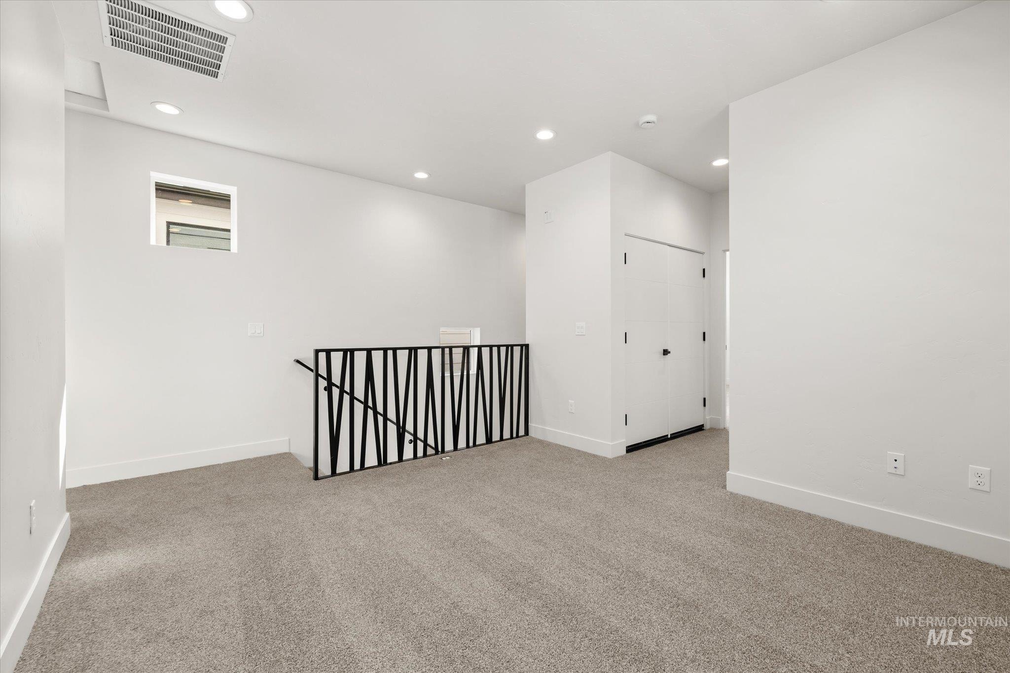 Spare room featuring light colored carpet and recessed lighting
