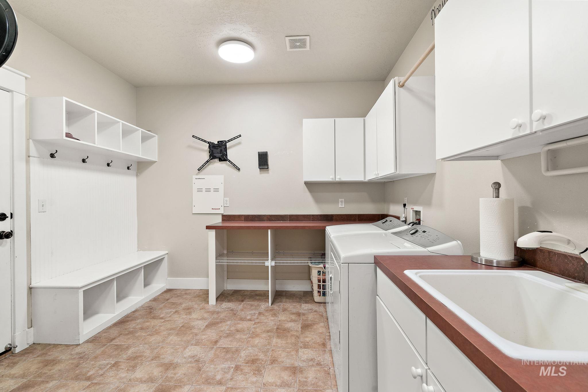 Washroom featuring separate washer and dryer and cabinet space