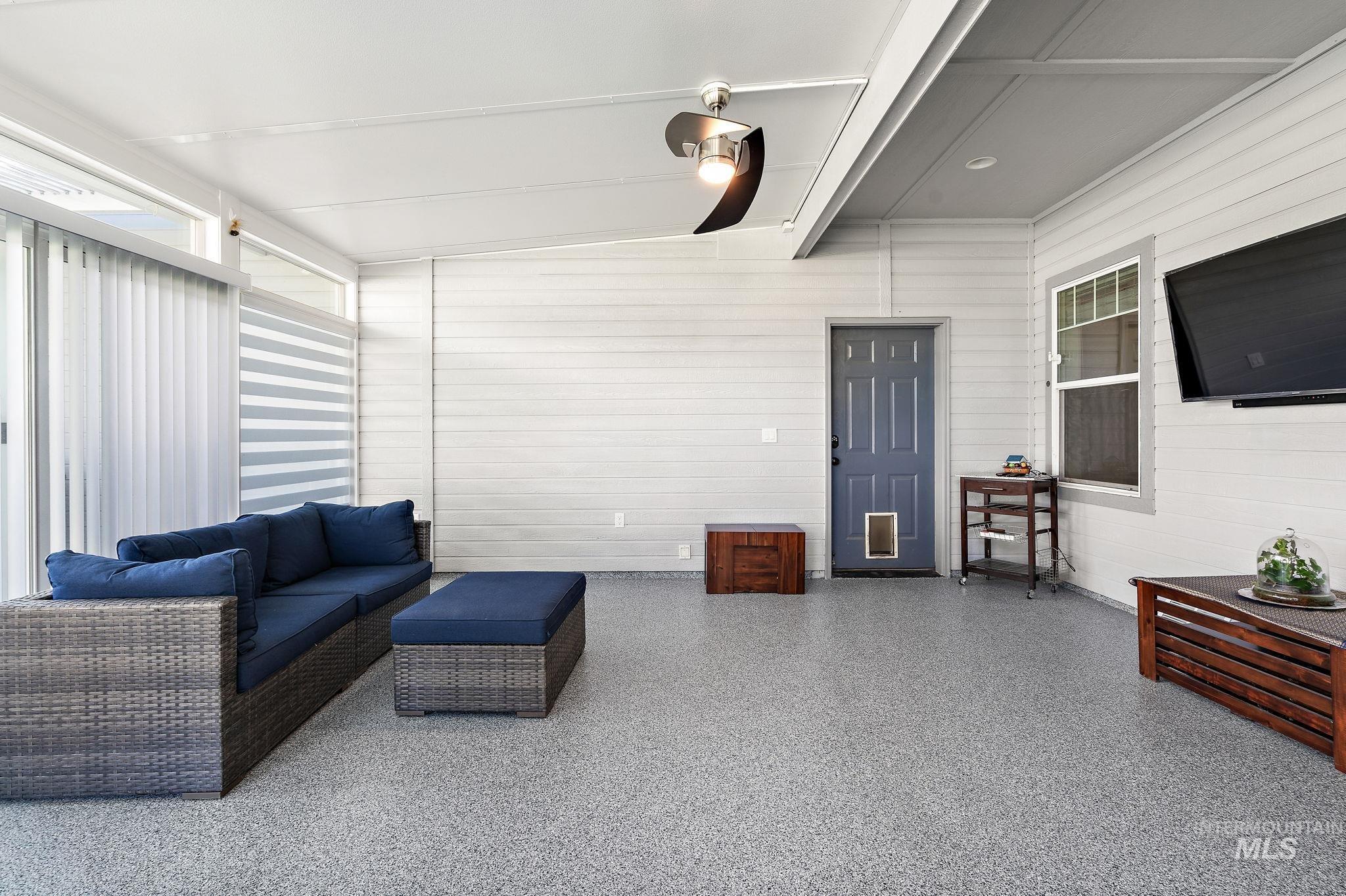 Interior space with wood walls, beamed ceiling, and speckle patterned floor