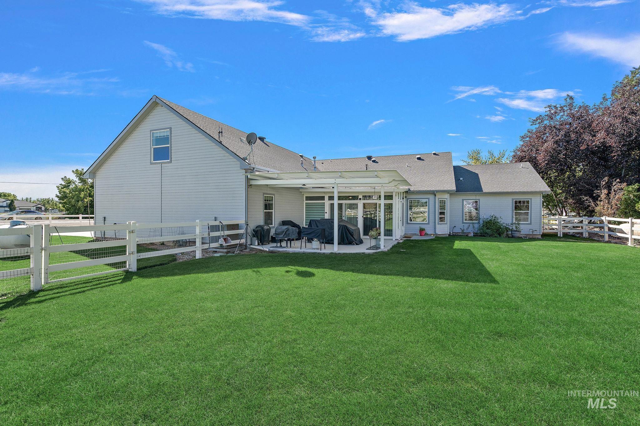 Back of house with a fenced backyard, a patio, and roof with shingles