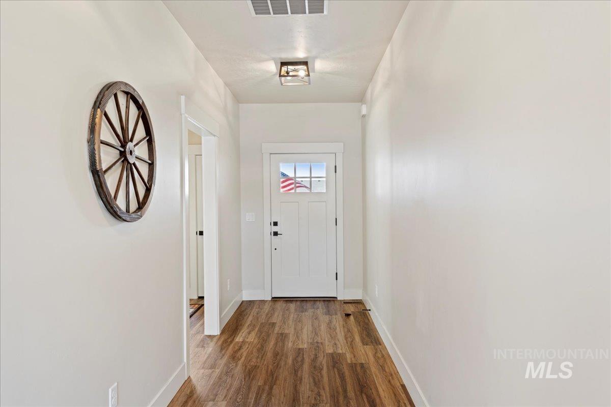Entryway with baseboards and wood finished floors