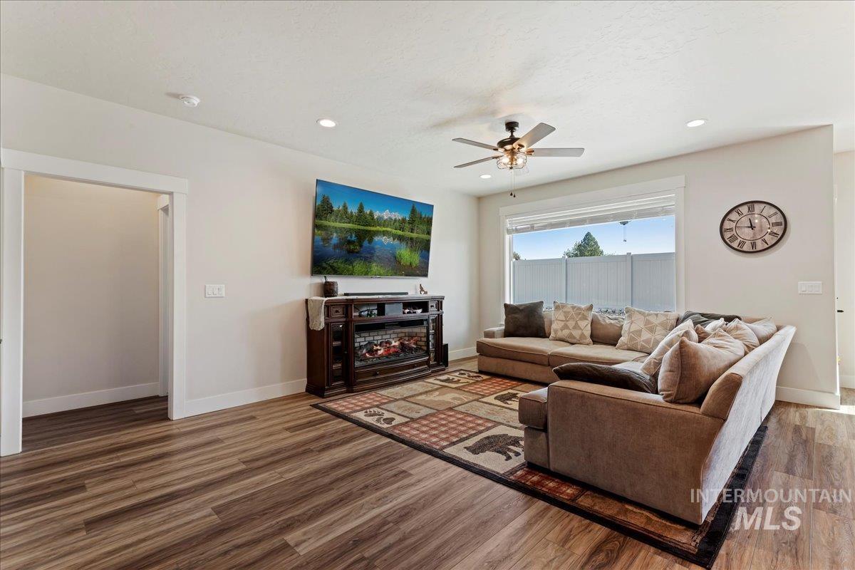 Living room with wood finished floors, ceiling fan, and recessed lighting