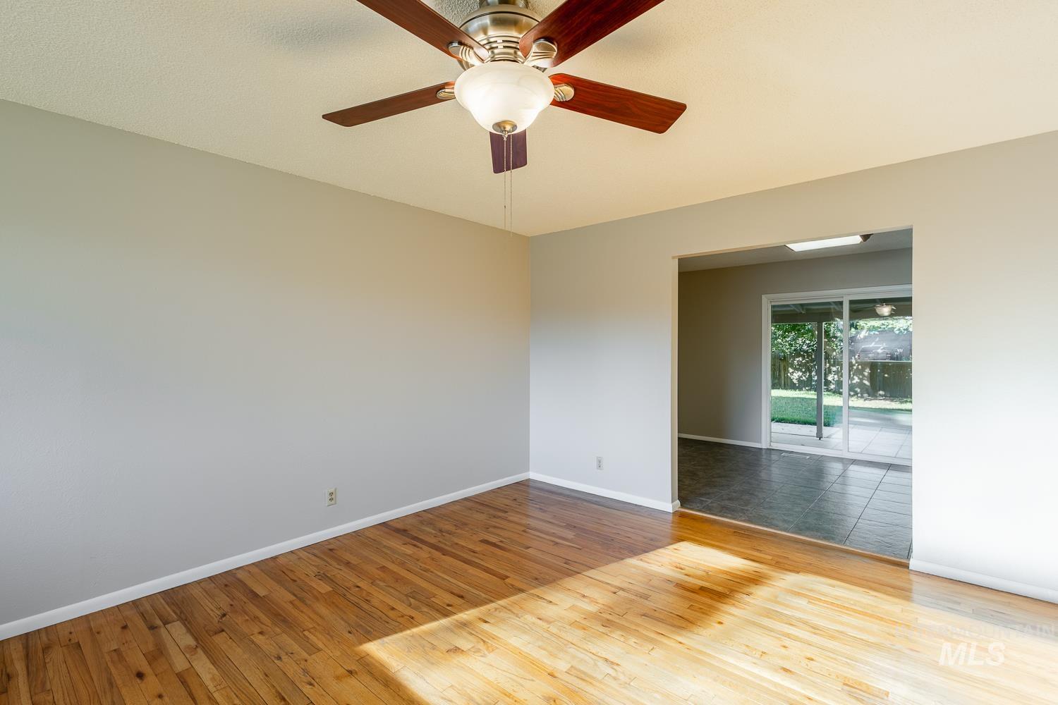 Empty room with light wood-style floors and ceiling fan
