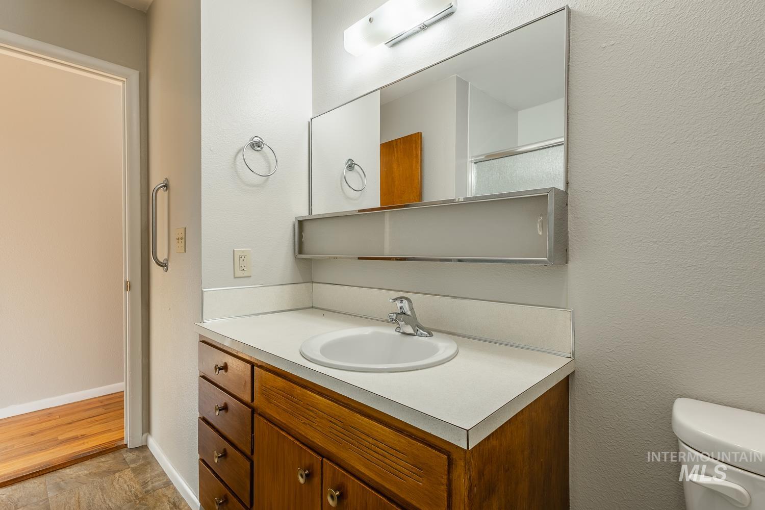 Bathroom featuring vanity and a textured wall