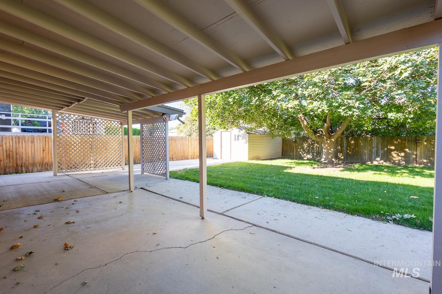 Fenced backyard with a patio area and a storage shed