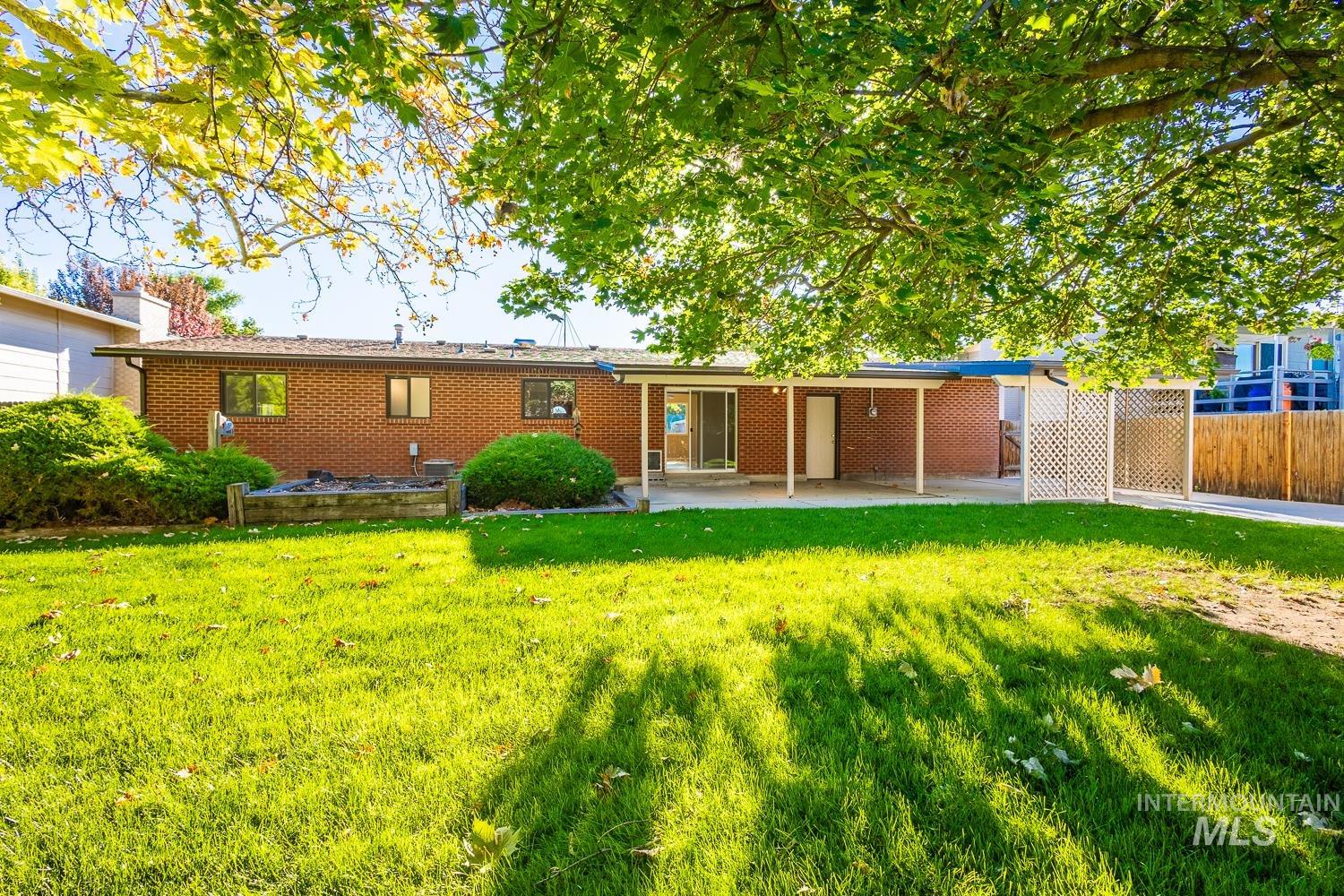 Back of property with a patio, brick siding, and a chimney