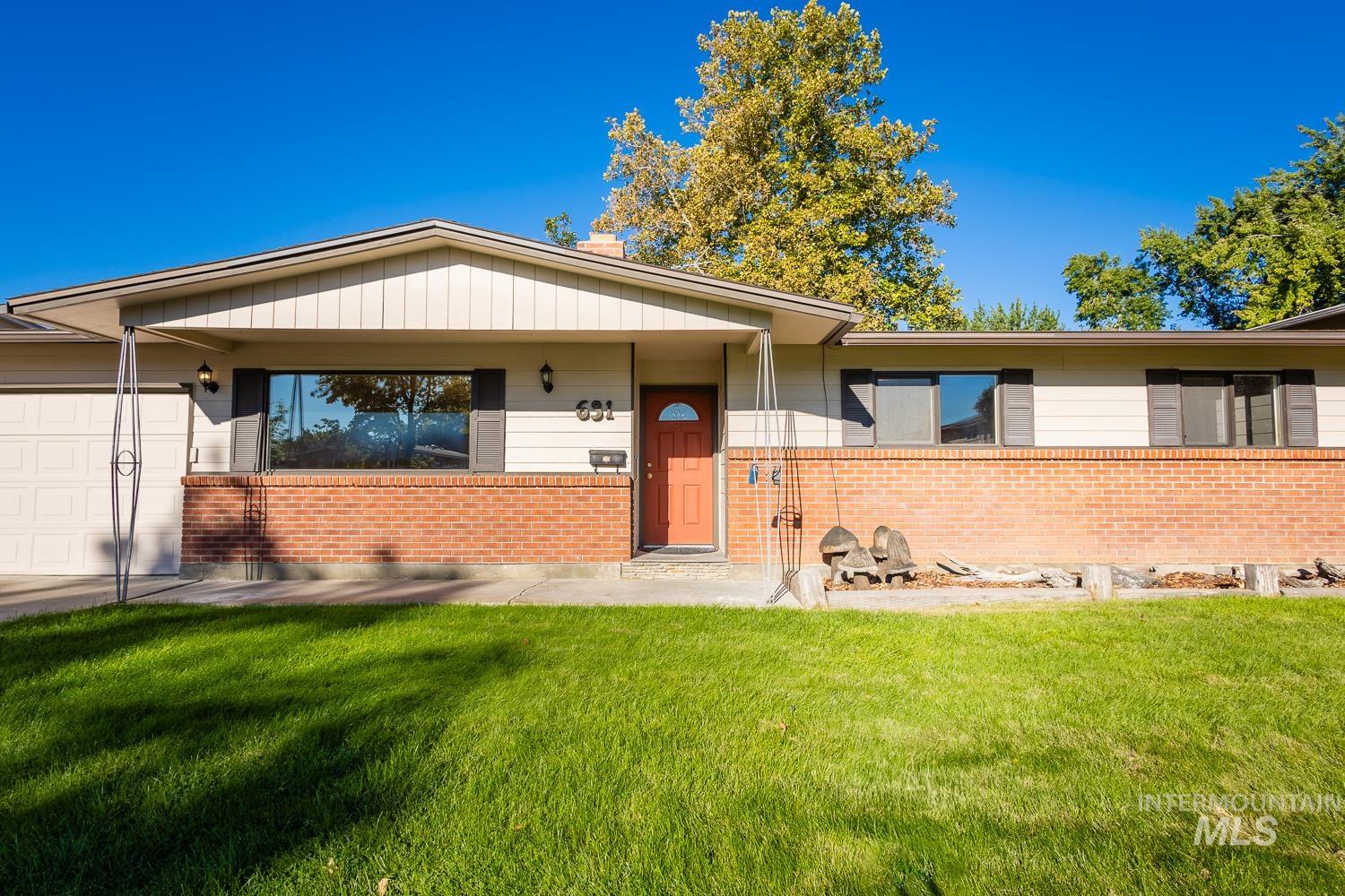 Ranch-style home with a front lawn, a garage, covered porch, and brick siding