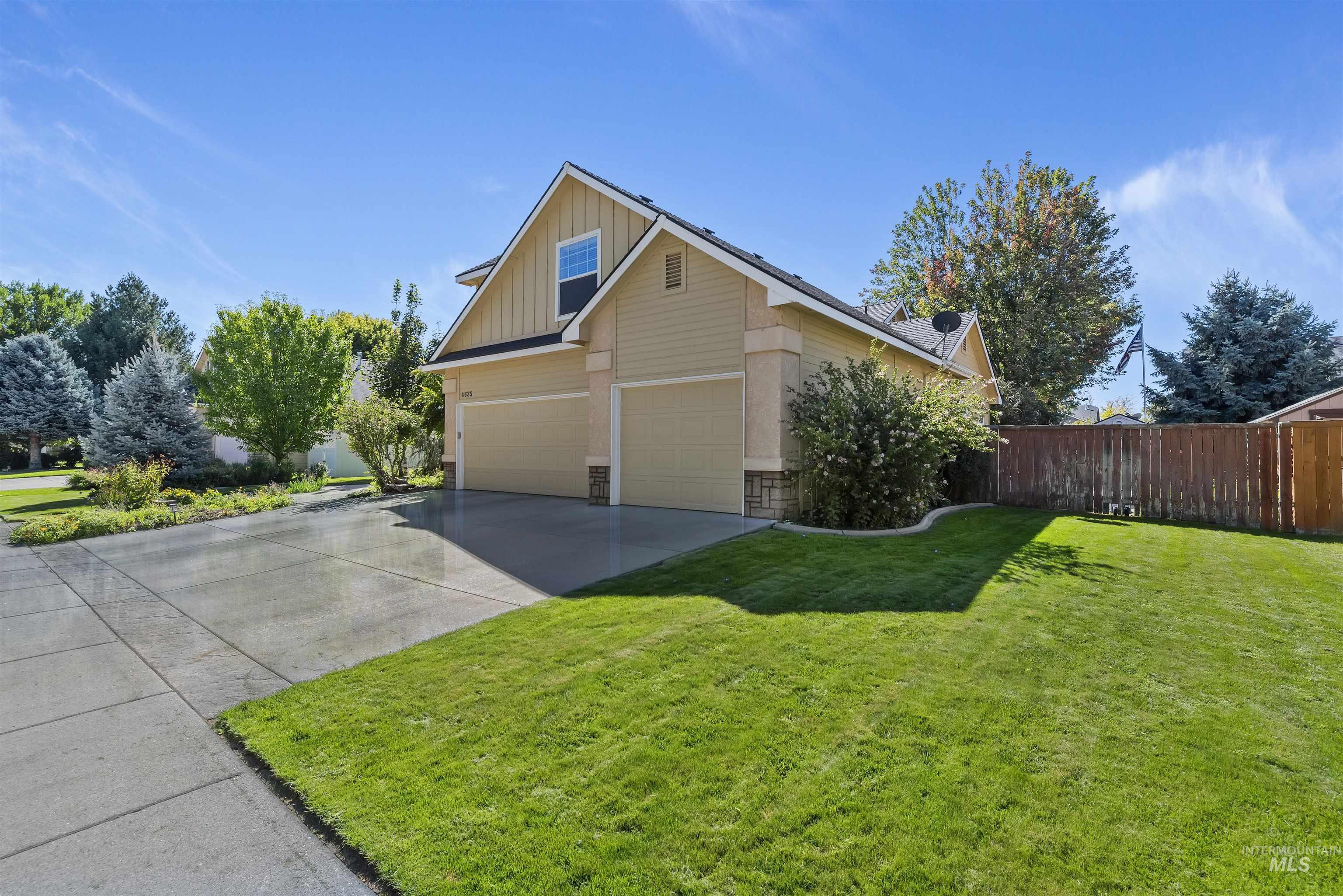 View of side of property featuring board and batten siding, driveway, and an attached garage