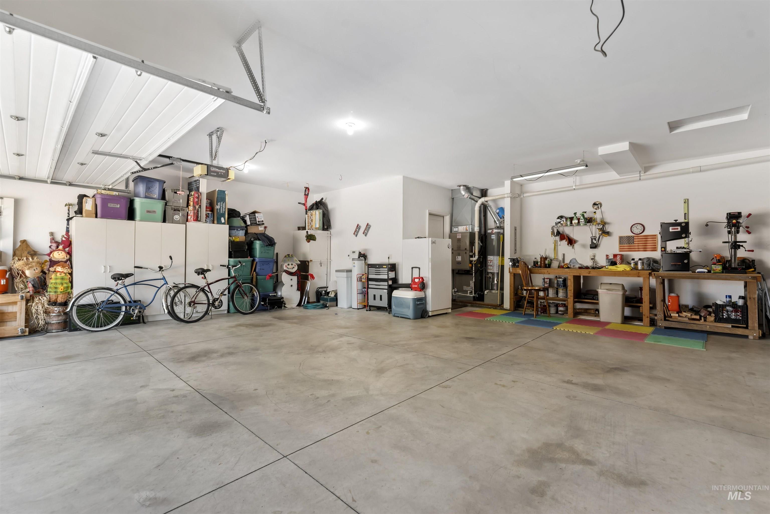Garage with a workshop area and freestanding refrigerator