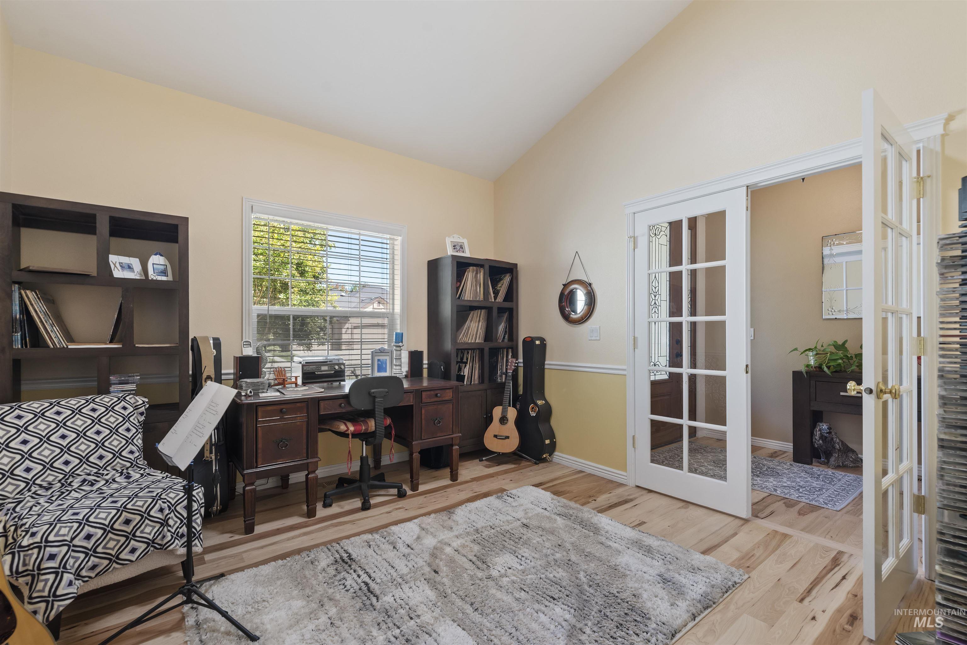Home office with french doors, light wood-type flooring, and lofted ceiling
