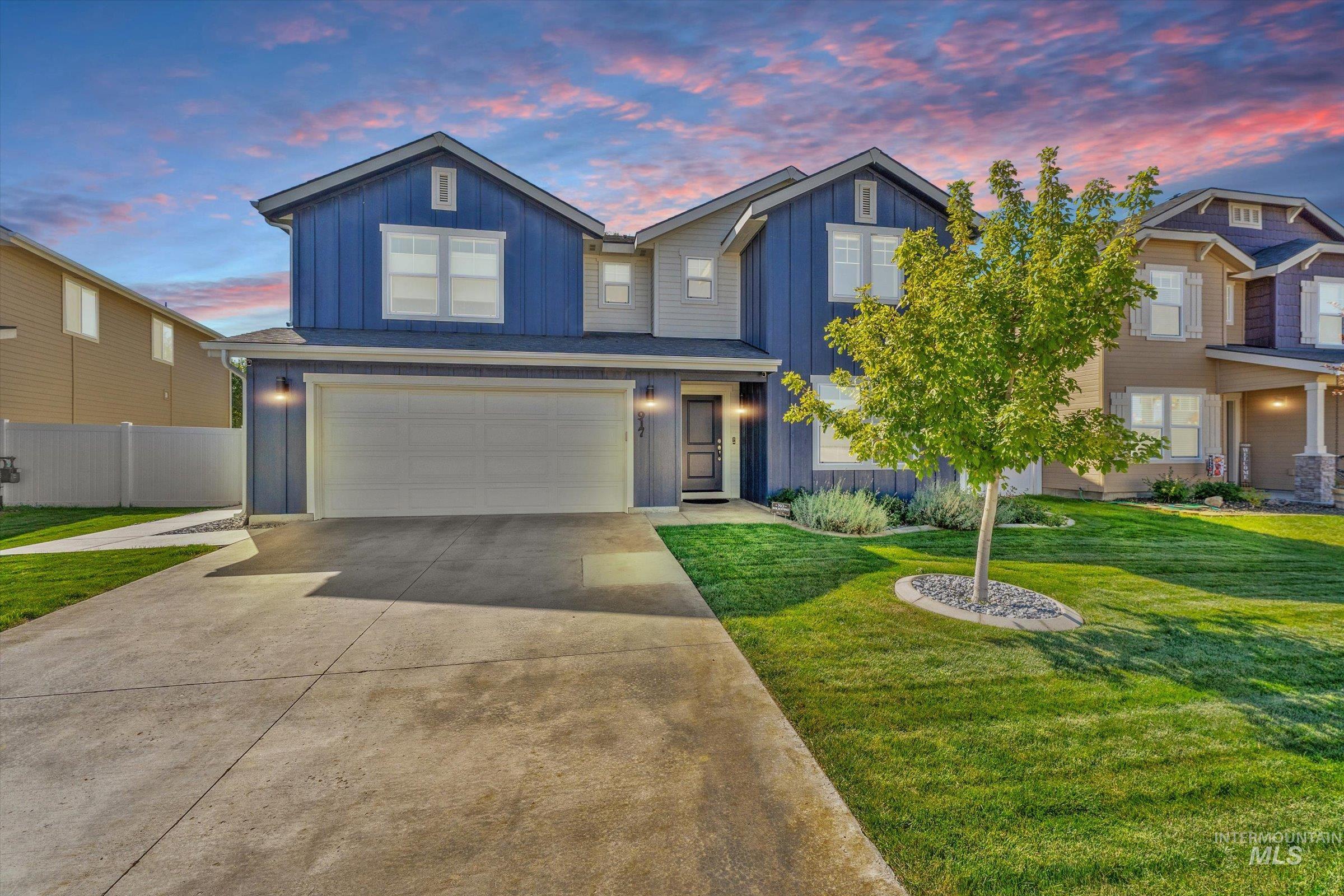 View of front of house with board and batten siding, concrete driveway, and an attached garage
