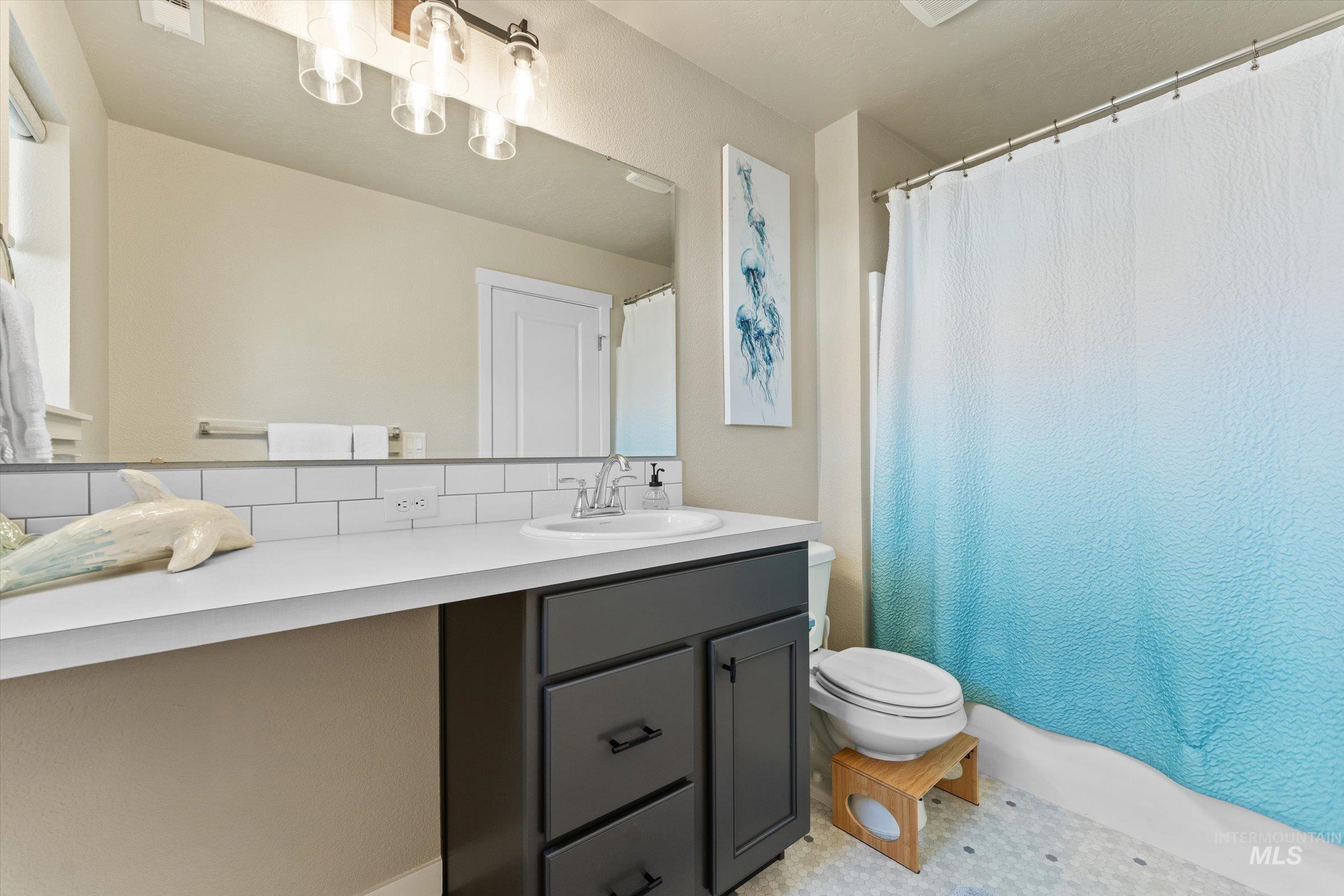 Full bath with vanity and a shower with curtain