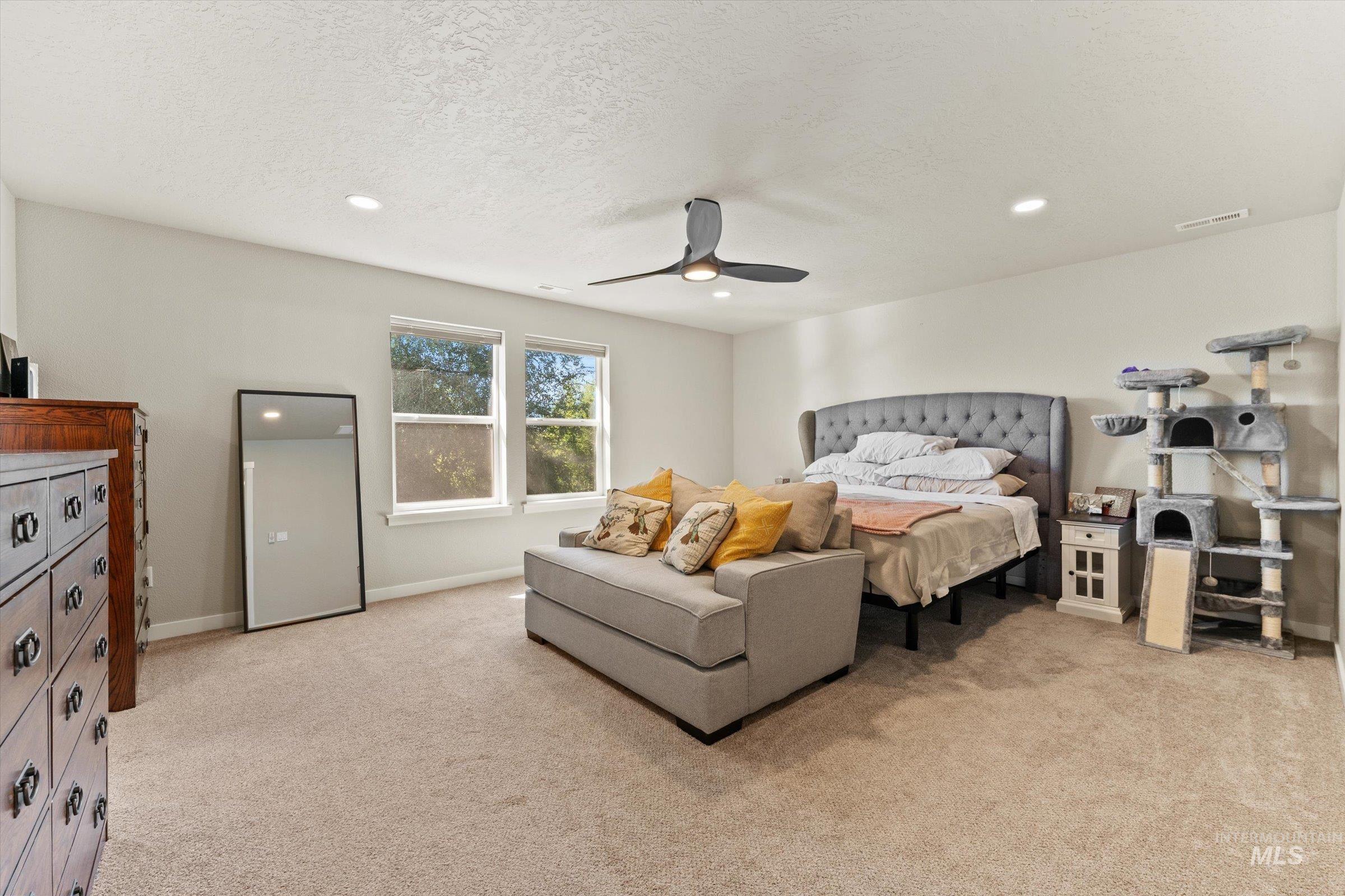 Bedroom featuring light colored carpet, recessed lighting, ceiling fan, and a textured ceiling