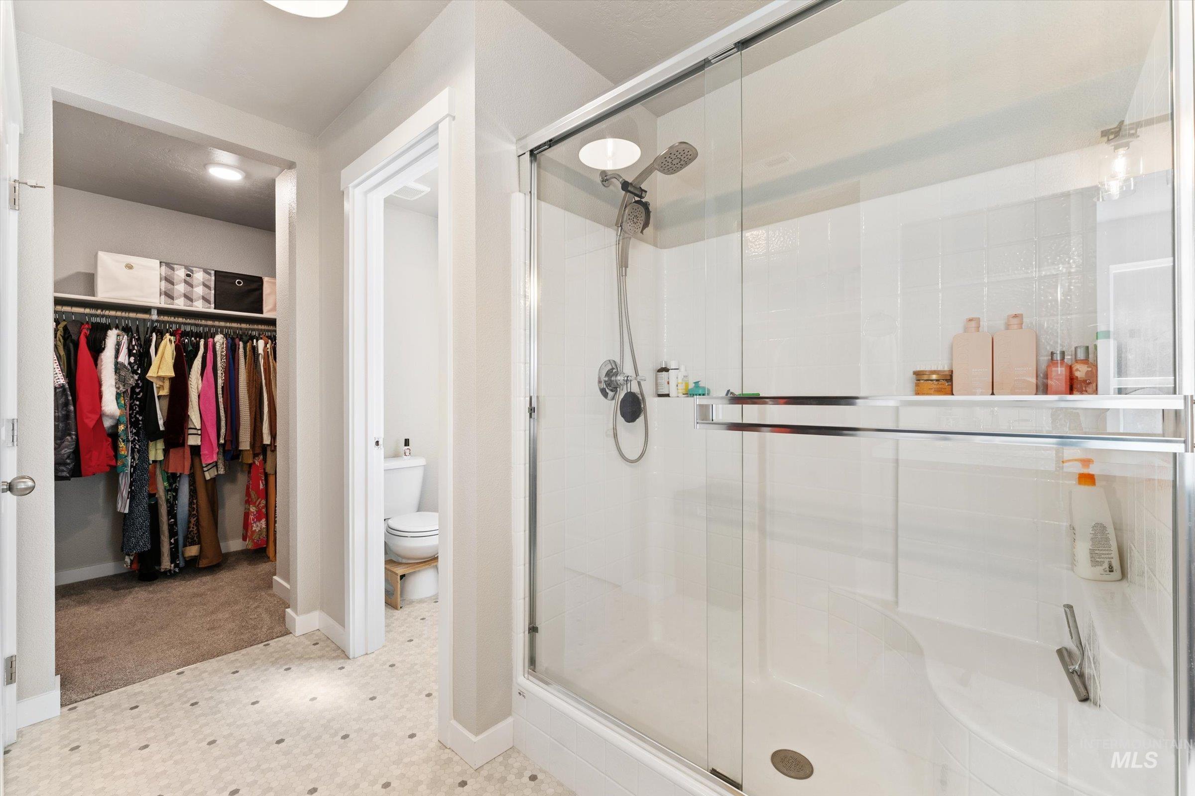 Full bathroom featuring a stall shower and a walk in closet